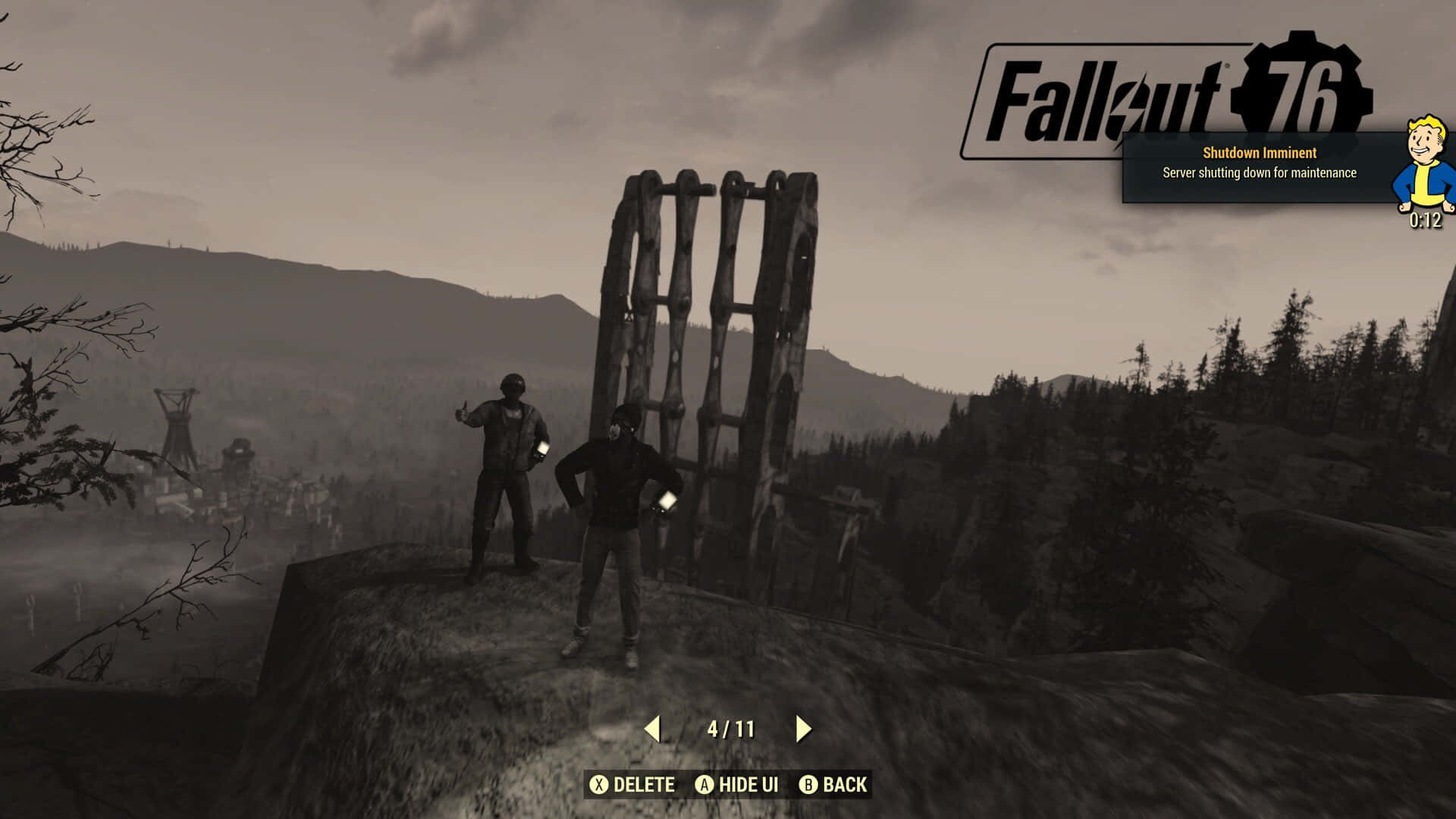 兩名玩家在 Fallout 76 中站在懸崖上，俯瞰廢墟景觀。