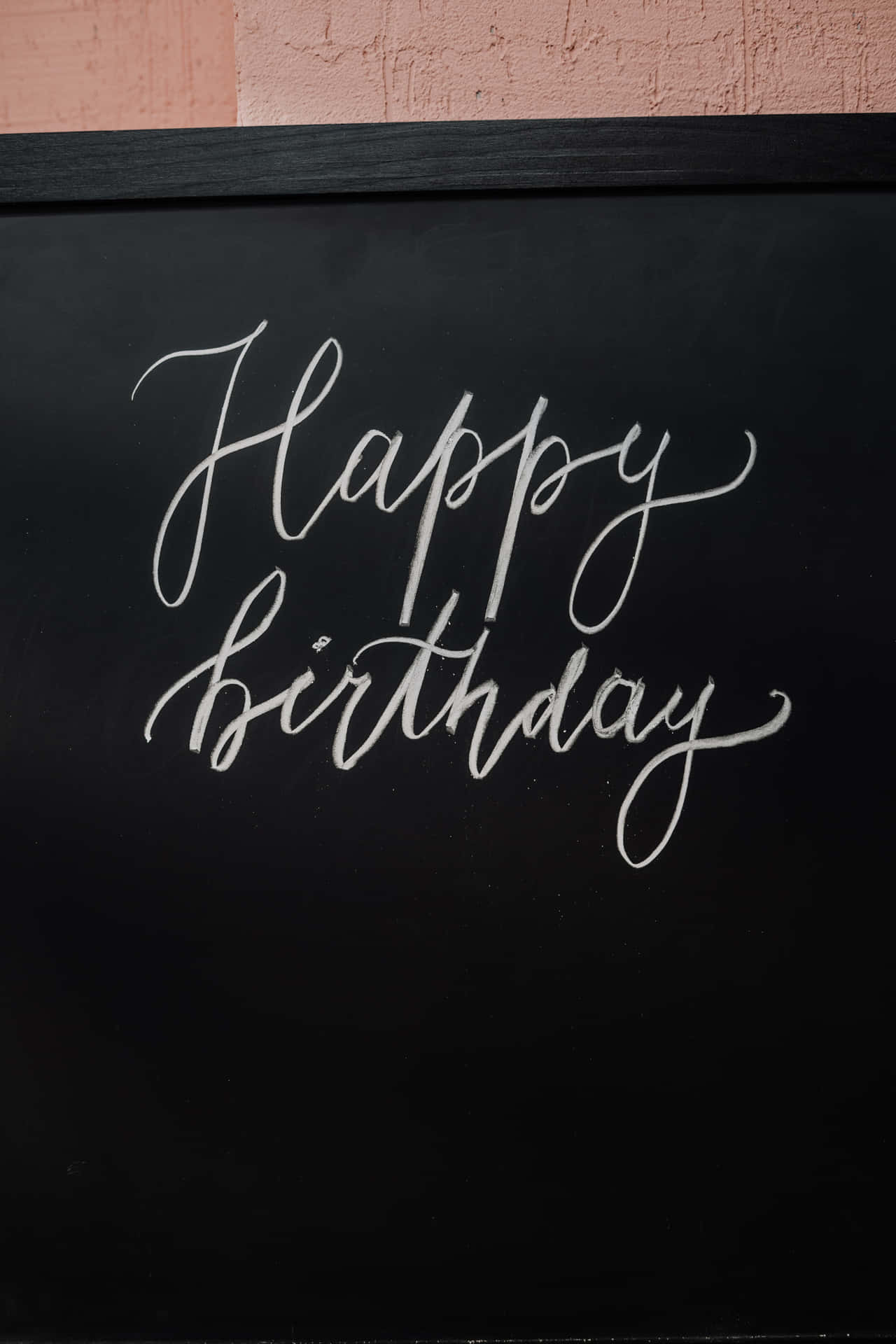 Happy Birthday 以白色草書寫在黑板上。