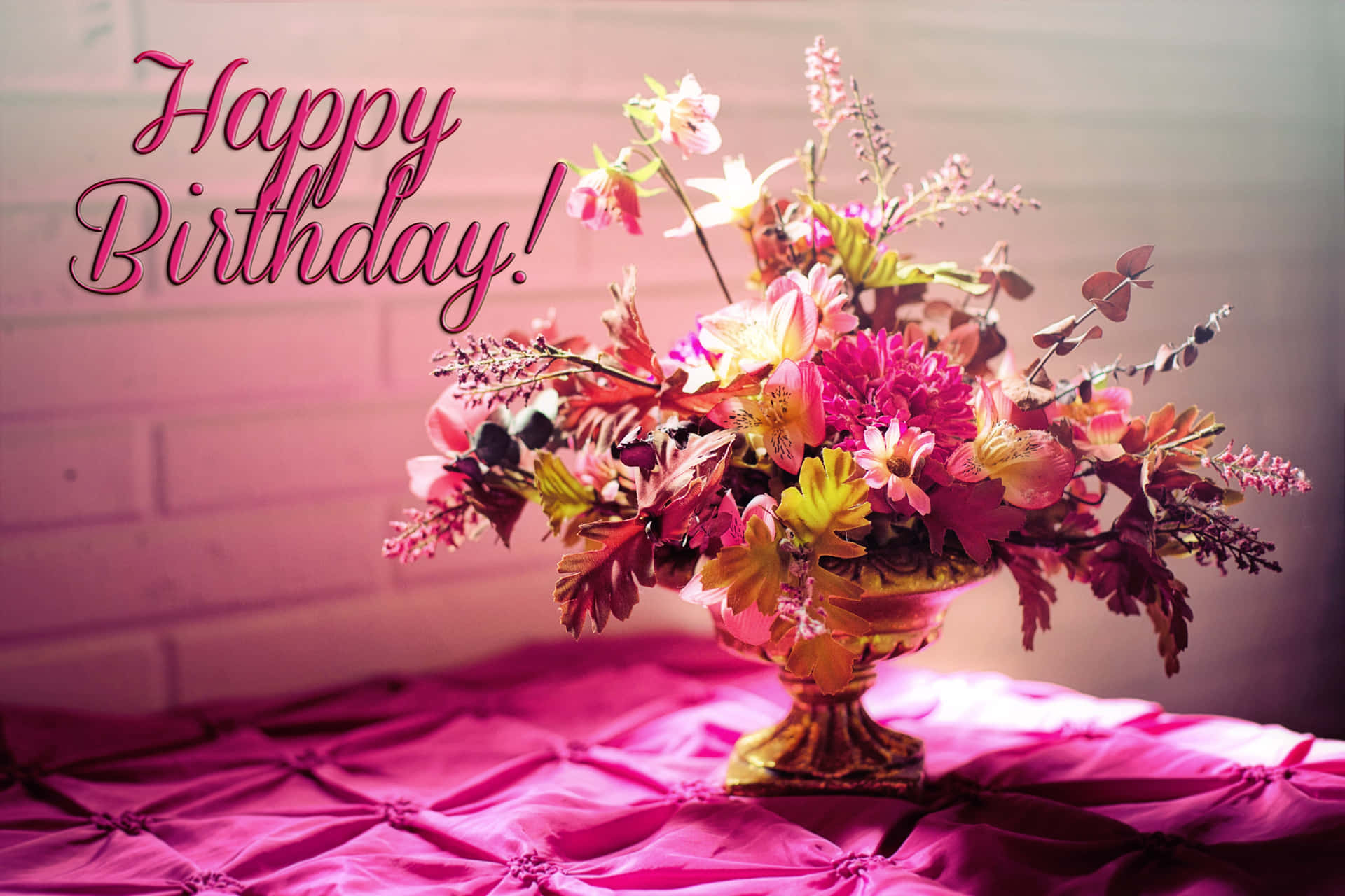 金色花瓶中的生日花束，粉紅色絎縫桌布，帶有「Happy Birthday!」文字。