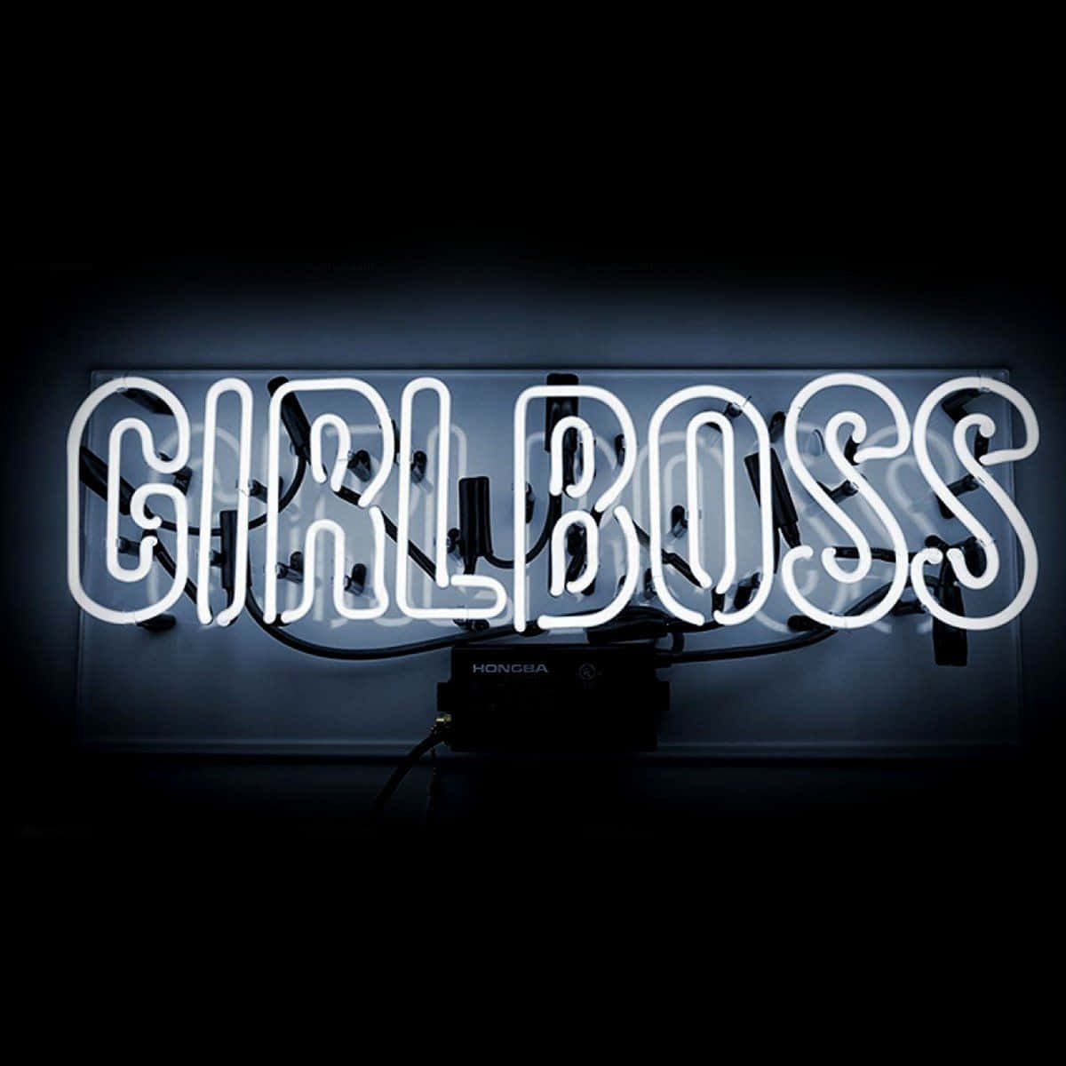 一個明亮的白色霓虹燈牌，上面寫著「GIRLBOSS」，背景為深色。