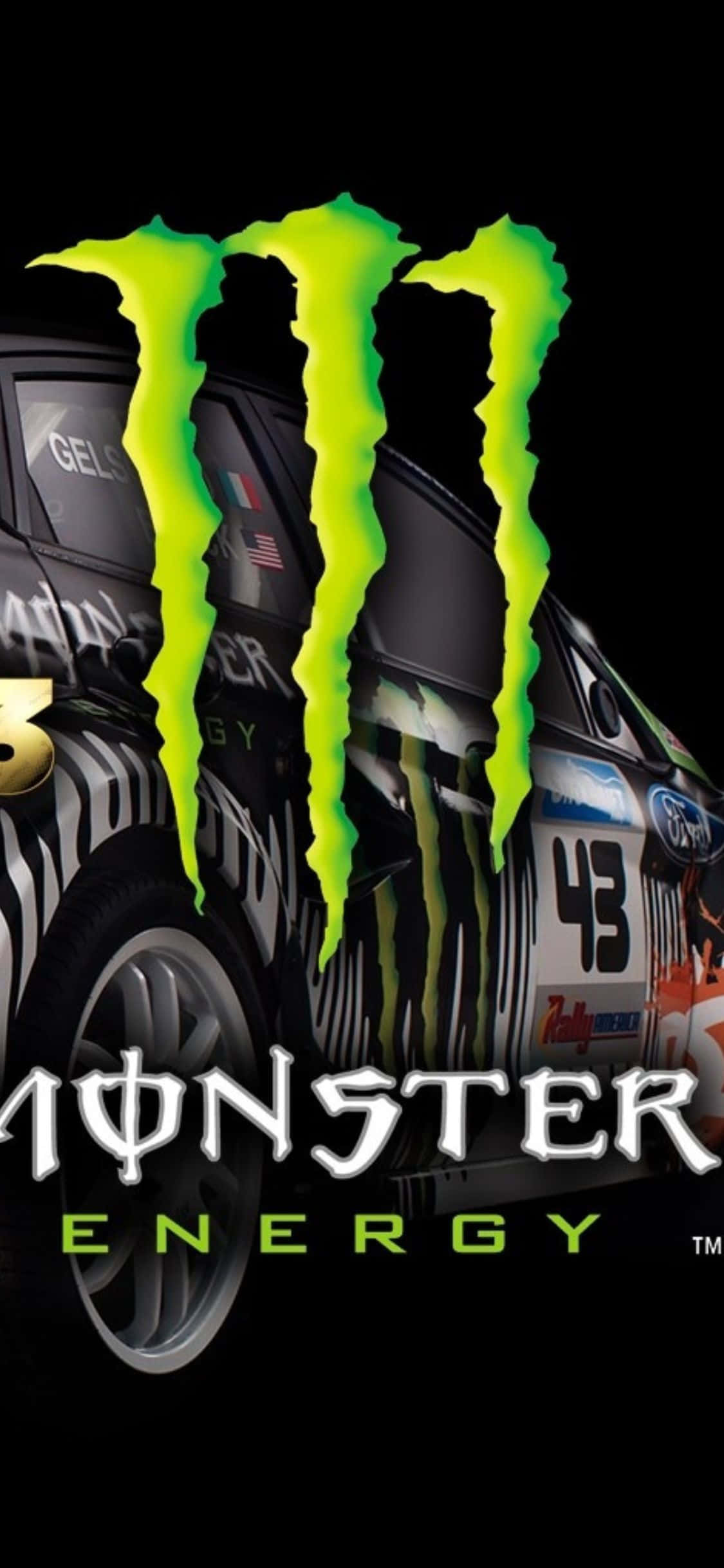 用 iPhone Xs 和 DiRT 3 挖掘你的速度與力量 壁紙 — 一輛帶有斑馬條紋和發光綠色Monster Energy標誌的黑色拉力賽車，主宰著黑暗的背景。