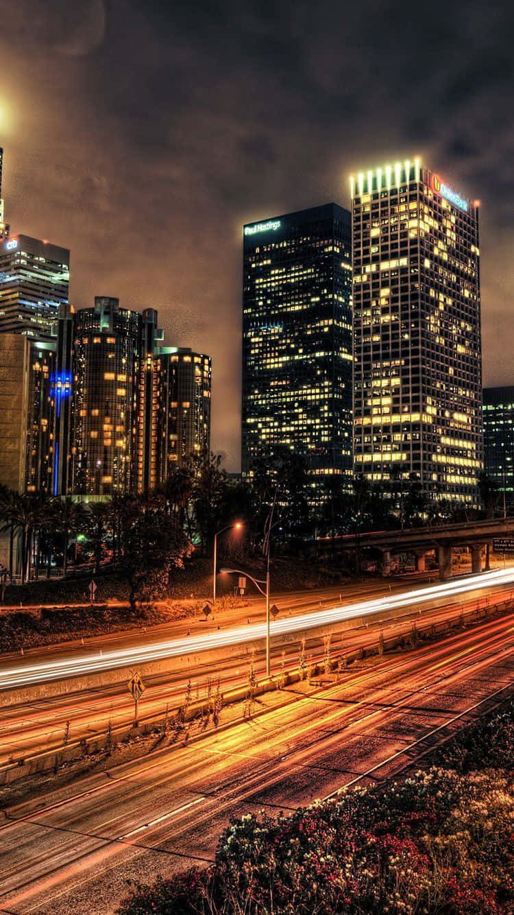 夜間城市天際線，燈火通明的建築物和移動車輛的燈光軌跡。