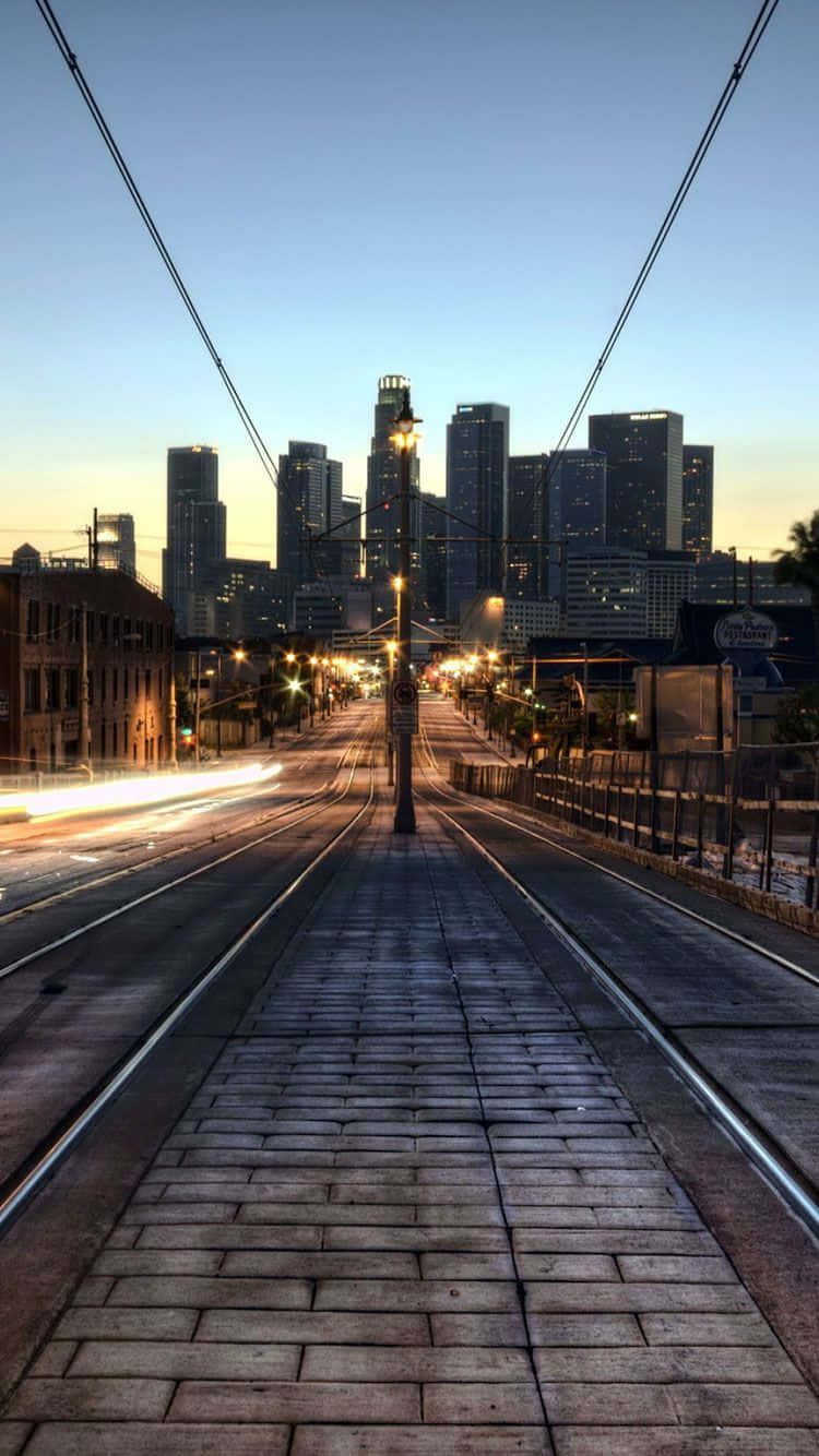 暮色中的空電車軌道，帶有光跡和背景的城市天際線