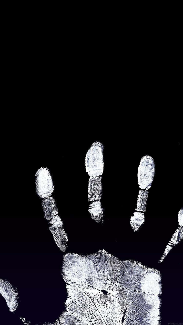 用 iPhone 輕鬆發揮創意 壁紙 — 在深黑色背景上，鮮明的白色手印和葉子印花形成高對比度的單色效果。