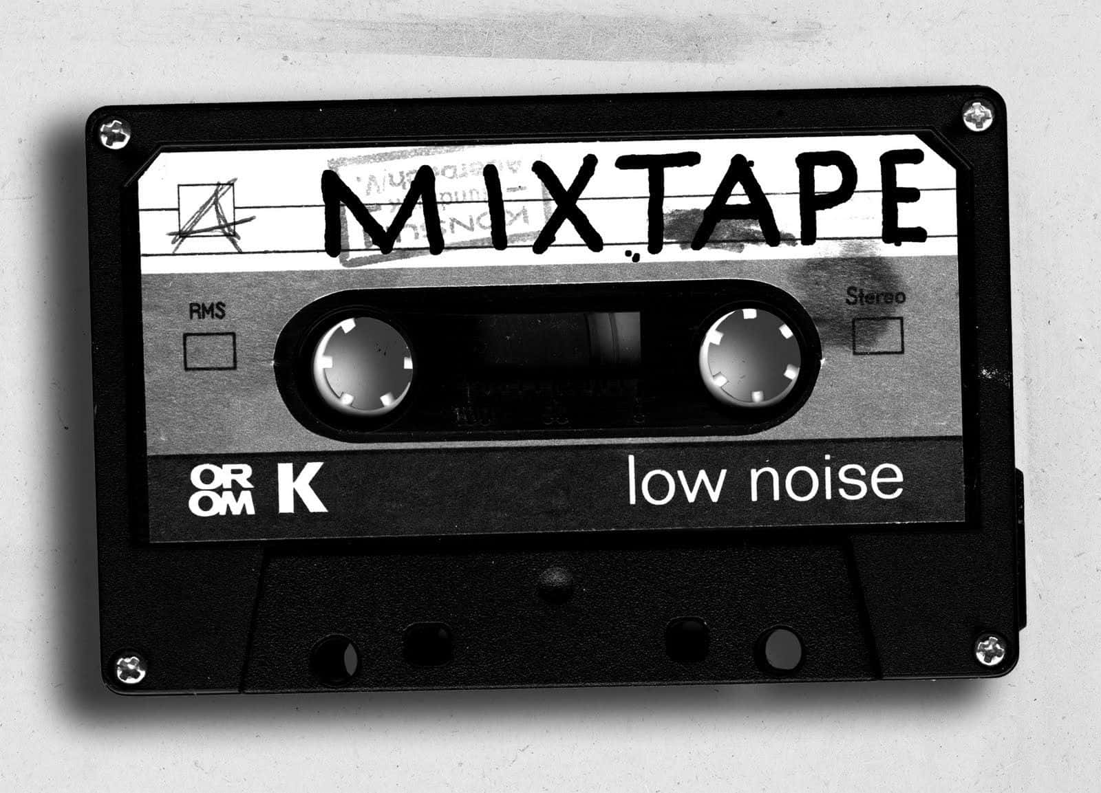 用 Mixtape 傾聽你最愛的音樂收藏 壁紙 — 一張黑白照片，展示一個標有「MIXTAPE」和「low noise」文字的復古卡式錄音帶，背景簡潔。