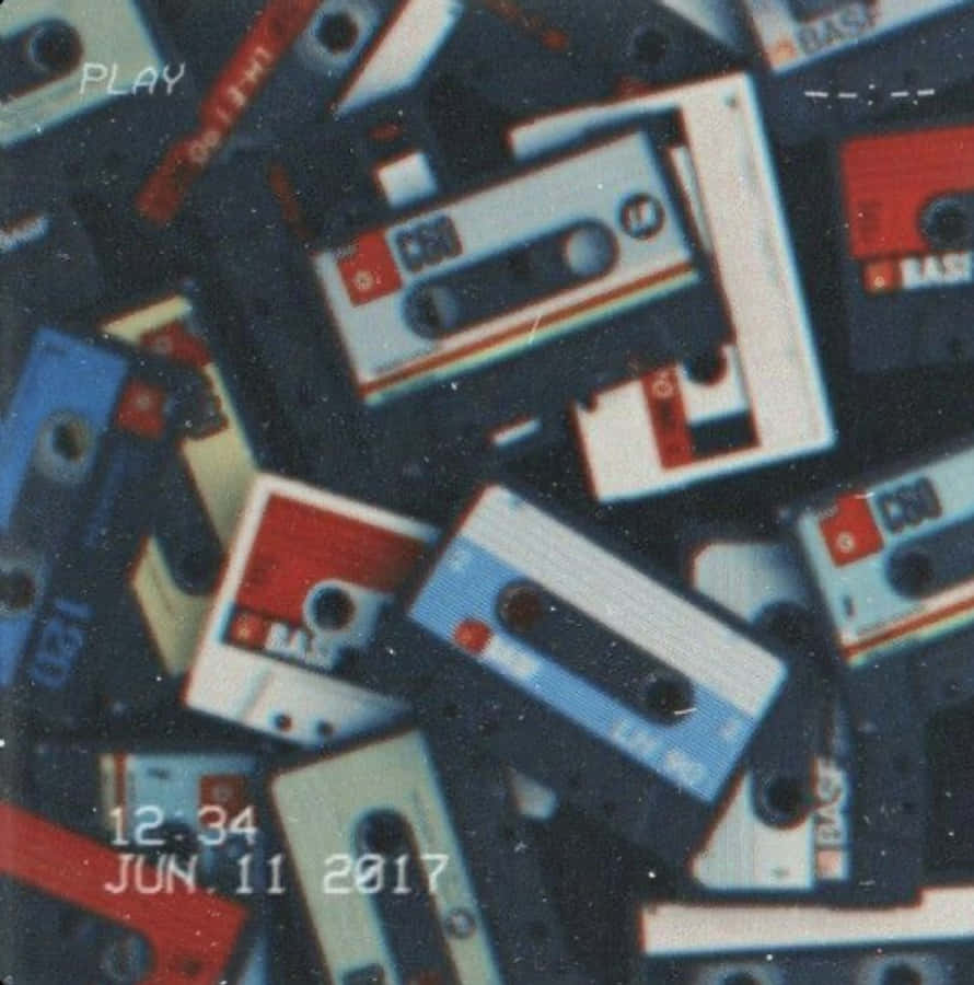 用 Mixtape 定義你的音樂身份 壁紙 — 一堆懷舊的藍、紅、白色復古錄音帶，帶有顆粒感復古濾鏡和時間戳疊加效果。