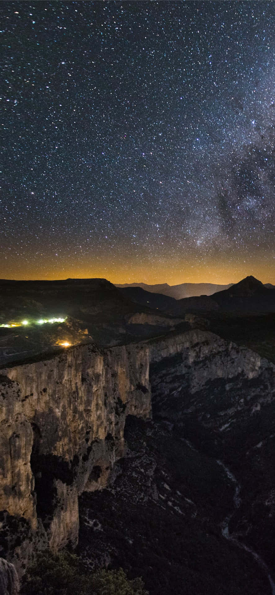 深邃山峽上空的星空與遠處燈光。