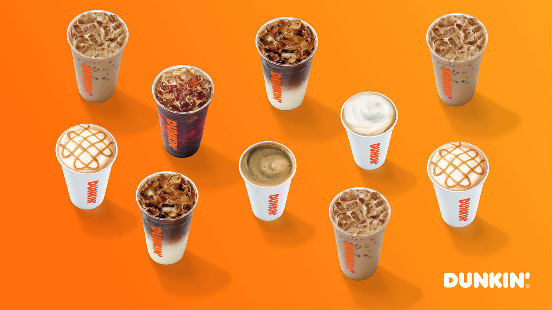 橙色背景上九杯Dunkin'冰咖啡飲品。