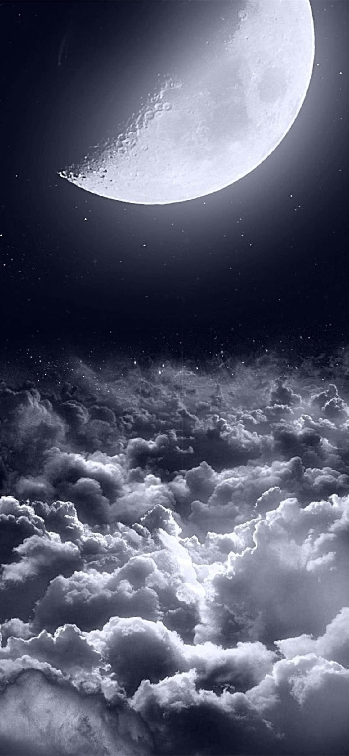 用iPhone捕捉夜空之美 壁紙 — 一輪明亮的彎月懸掛在繁星點點的夜空下，下方是戲劇性的紋理雲海。