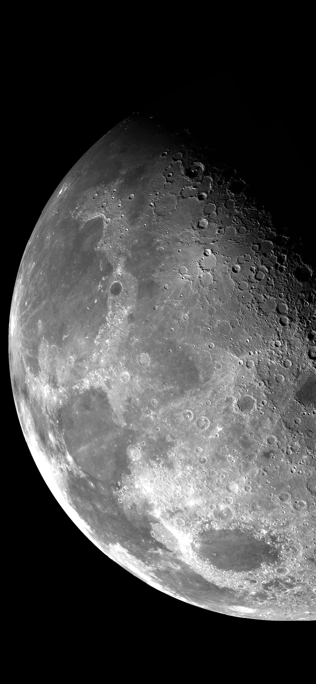 用iPhone欣賞月光下的寧靜夜晚 壁紙 — 以黑色虛空為背景的月球隕石坑表面高解像度灰階特寫。