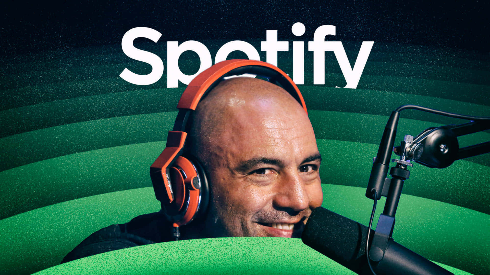 用Spotify開啟你的音樂聆聽體驗 壁紙 — 一位微笑的男子戴著橙色耳機，對著咪高峰說話，背景是綠色的Spotify品牌背景。
