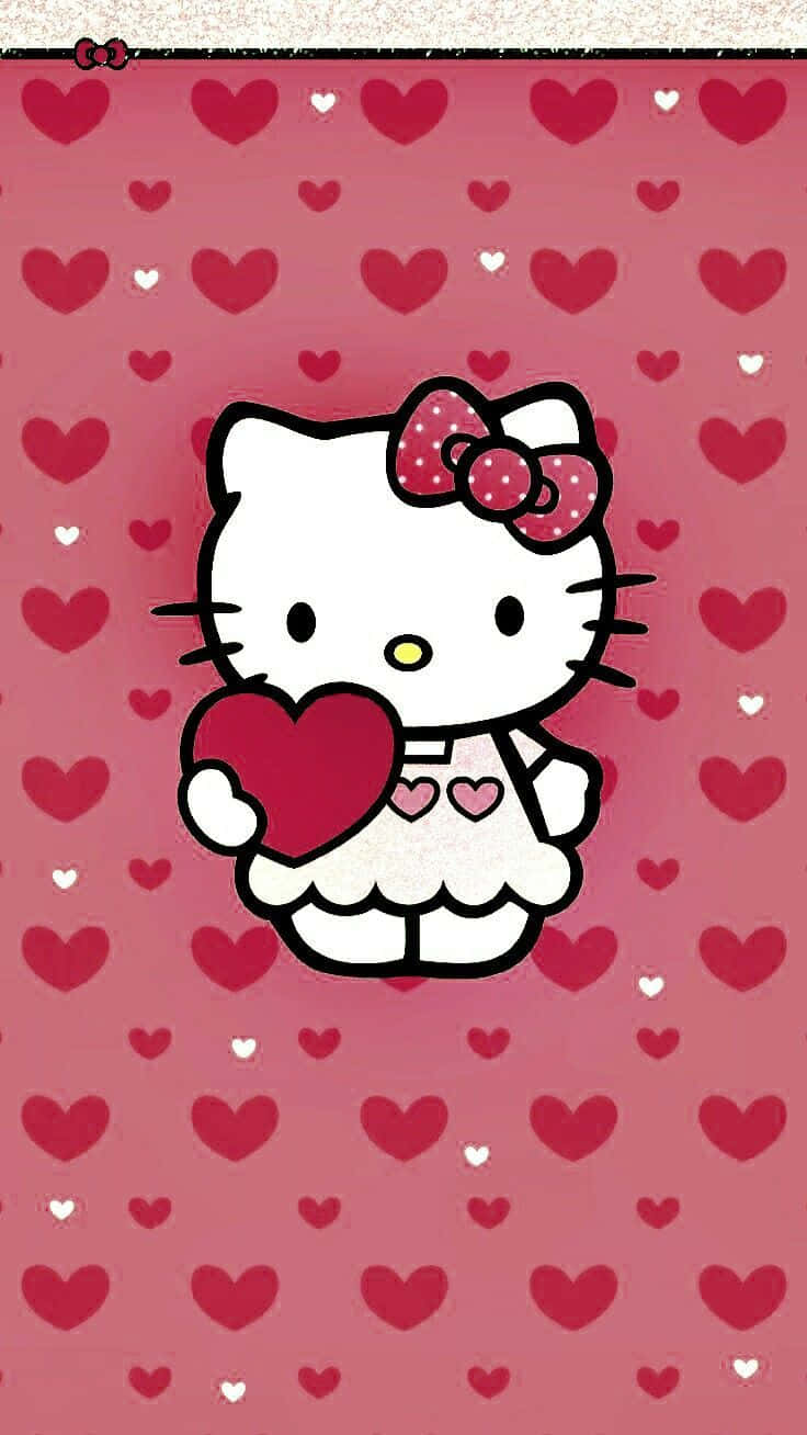 Hello Kitty 在心形圖案的粉紅色背景上手持一顆心。