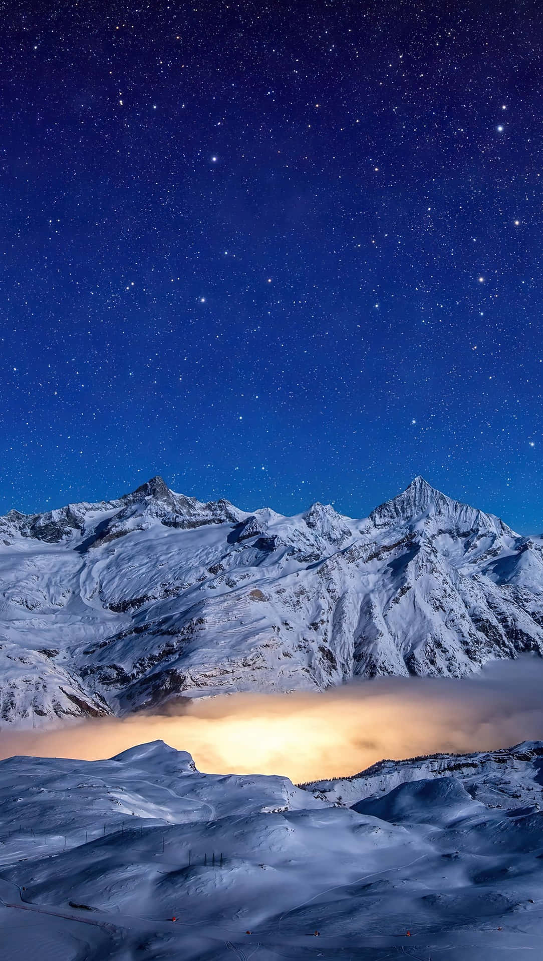 星空下的雪山，下方有發光的雲層。