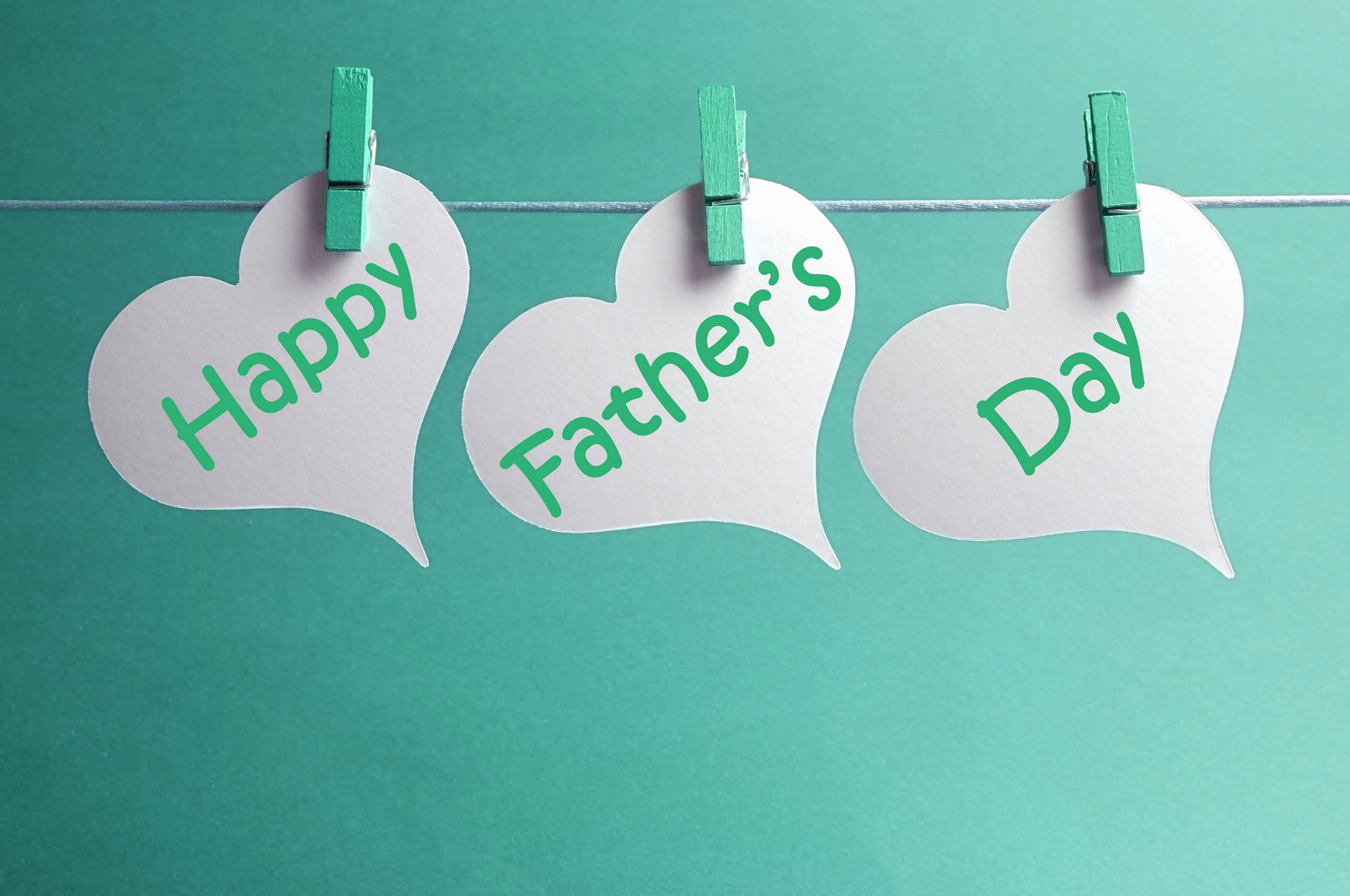 三個心形紙牌寫著 Happy Father's Day，夾在鐵線上。