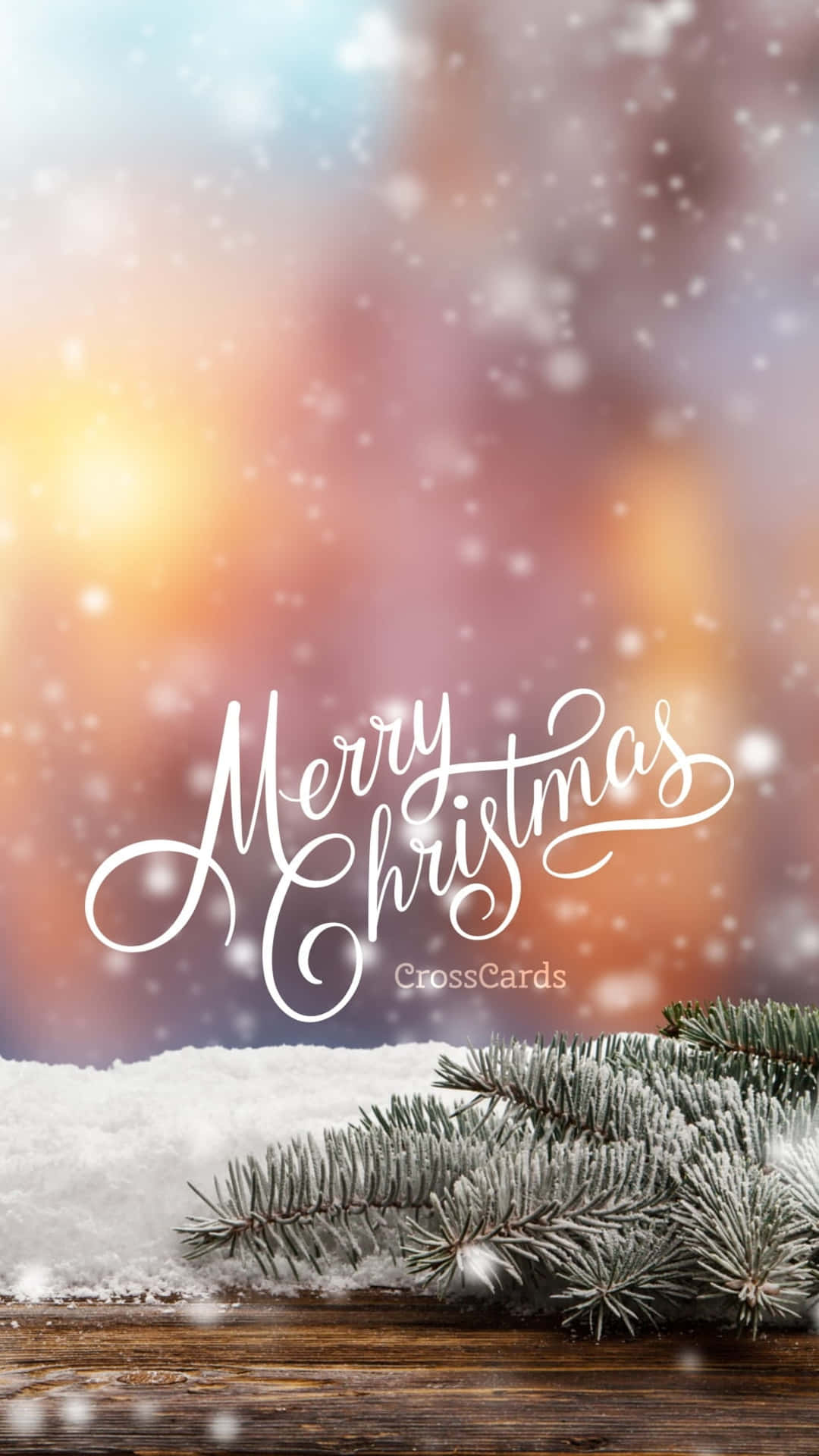 結霜的松樹枝在雪白的木頭上，帶有「Merry Christmas」文字，背景是溫暖的日落散景。