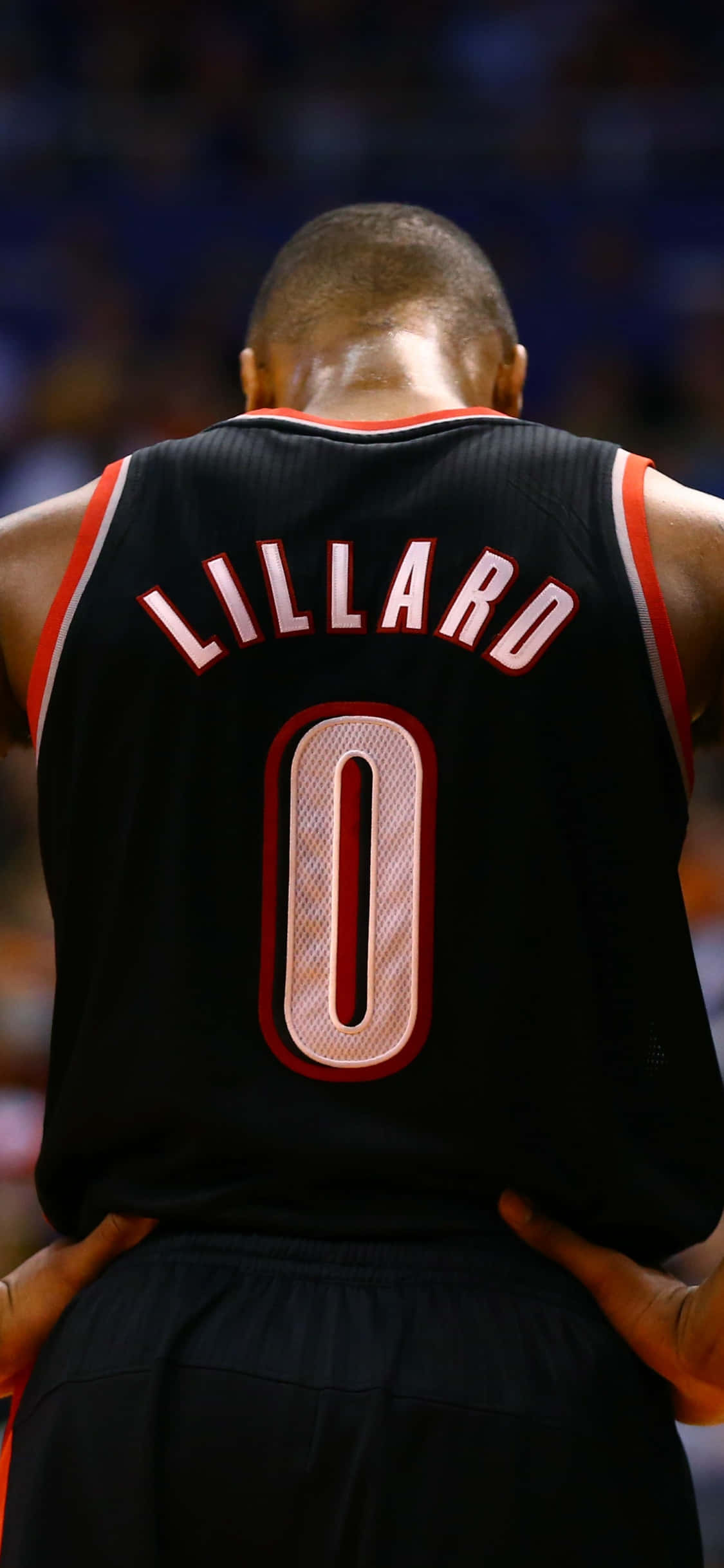 用新 iPhone Xs 跟蹤進步你的投籃 壁紙 — 籃球運動員 Damian Lillard 身穿黑色零號球衣站在球場上的背面照。