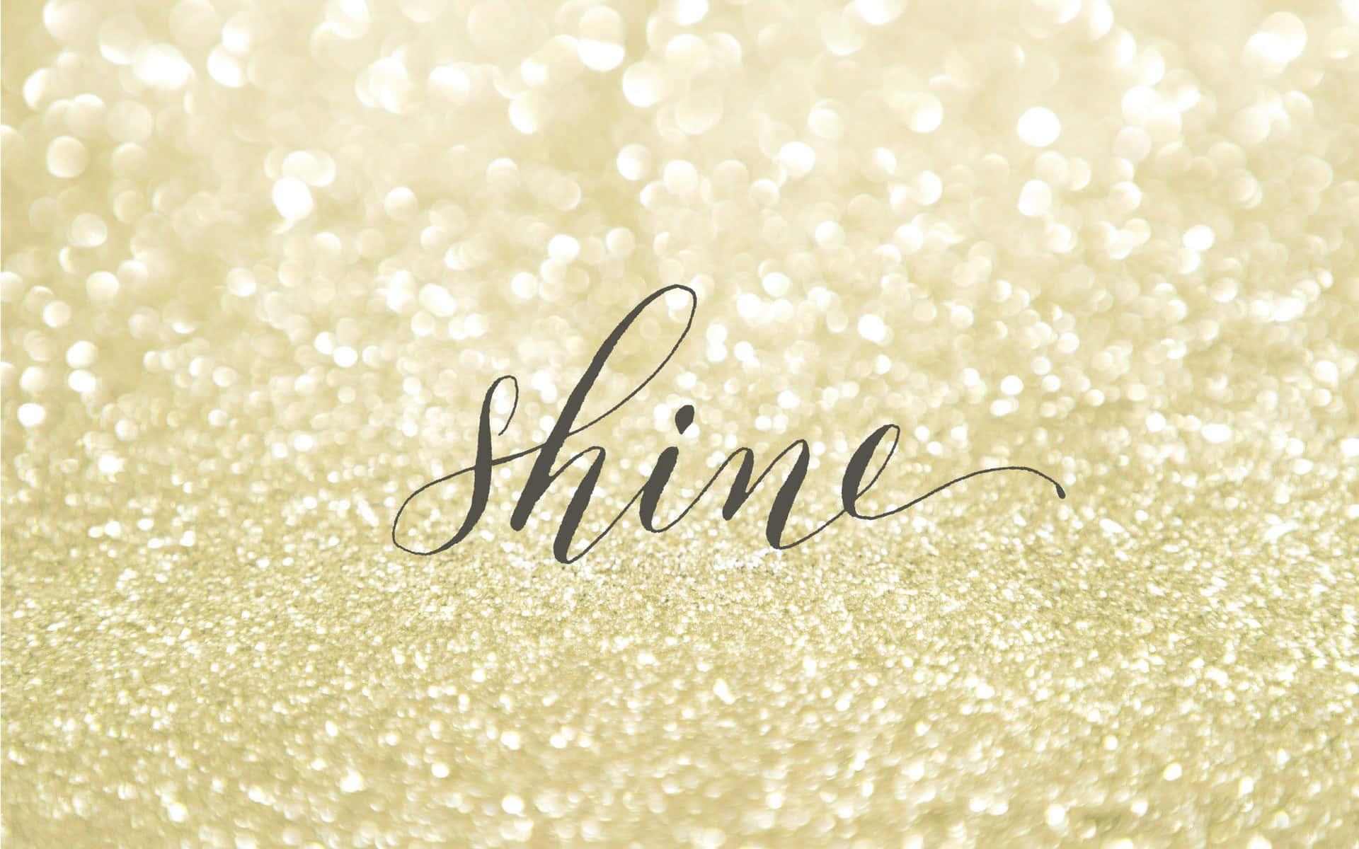 金色閃粉背景上的黑色草書「shine」一詞。