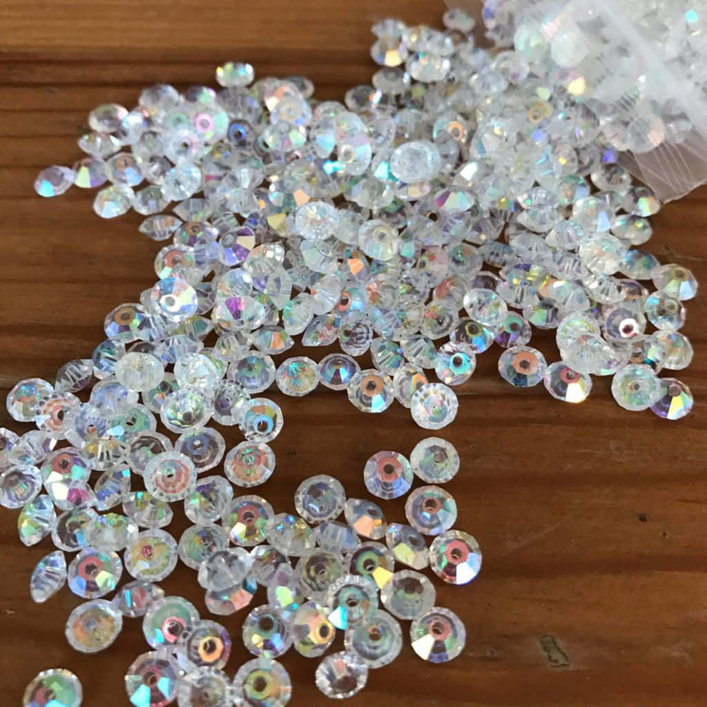 閃亮的彩虹色水晶珠子灑在木桌上。