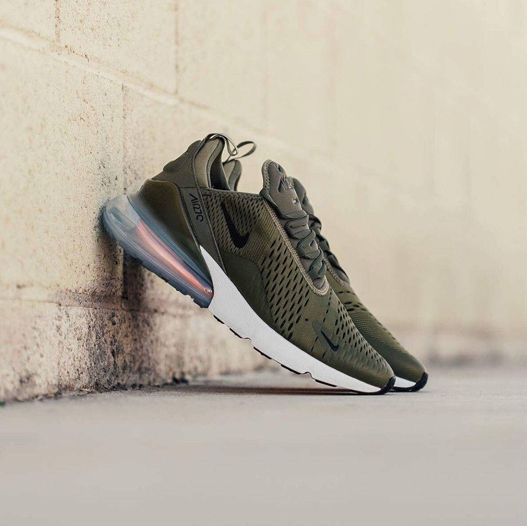 橄欖綠色Nike Air Max 270運動鞋靠在混凝土牆上。
