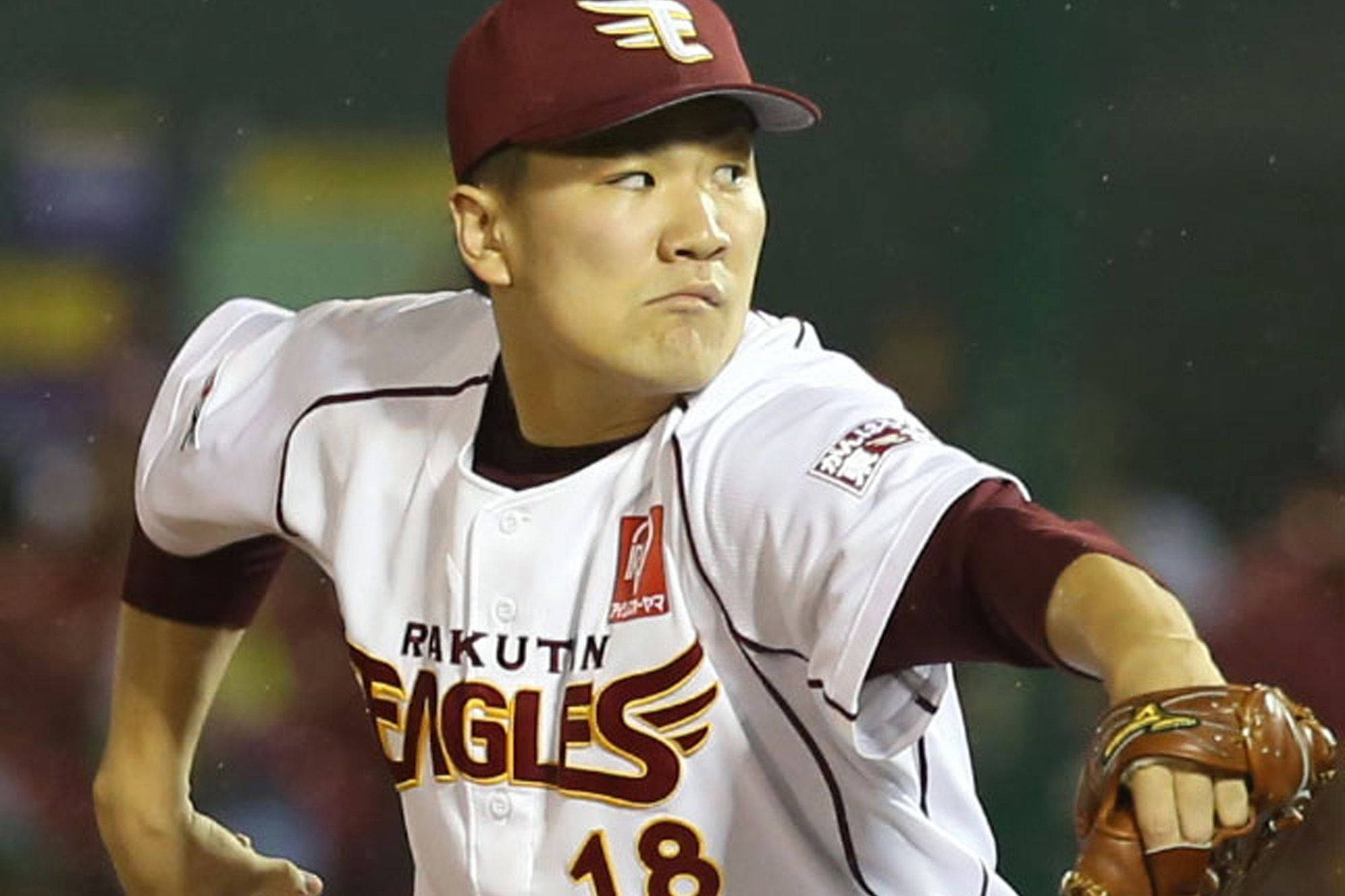 田中將大專注比賽表情 壁紙 — 一名身穿樂天金鷹隊球衣的棒球投手在球場燈光下準備投球。