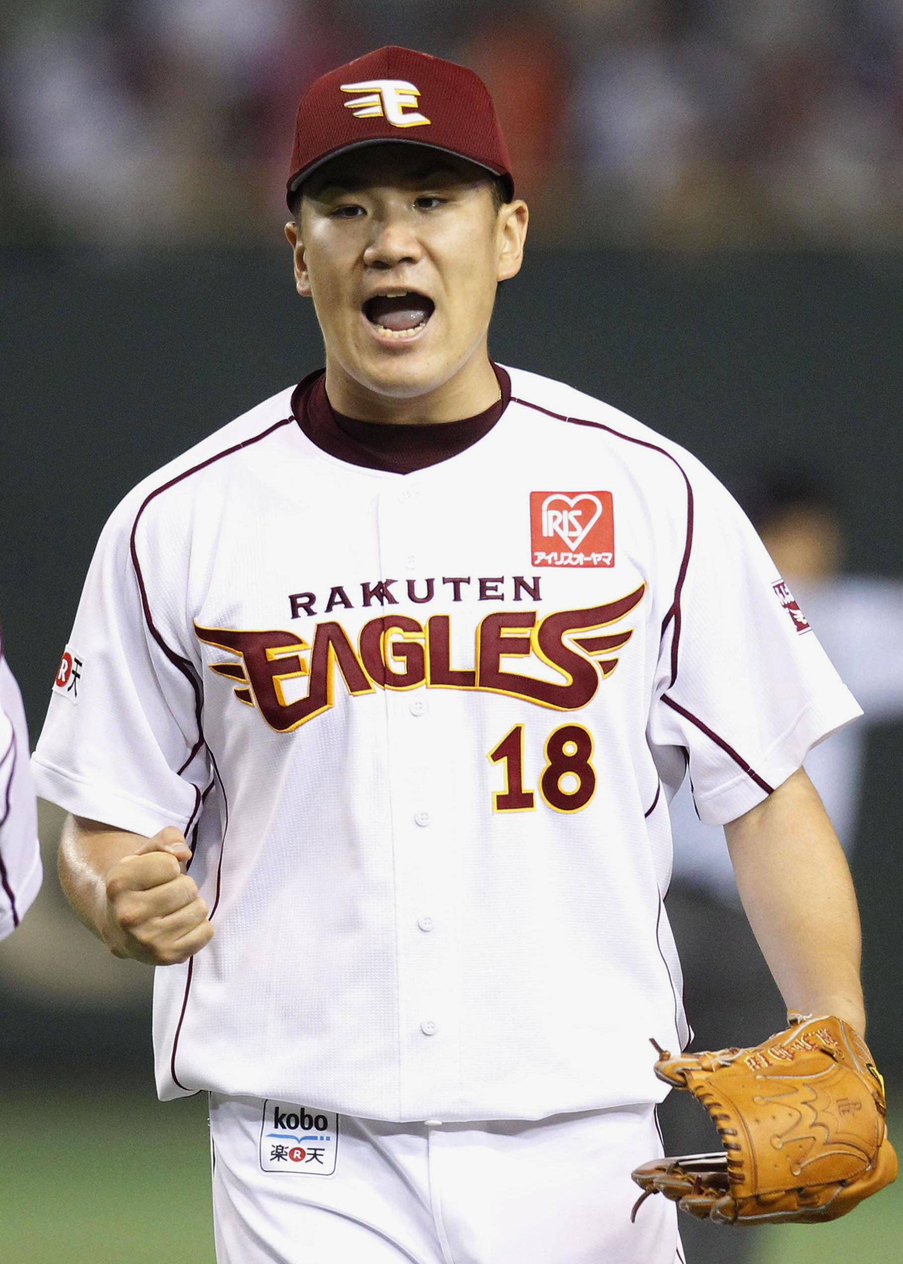 田中將大戴紅色棒球帽 壁紙 — 一名身穿樂天金鷹隊球衣的棒球選手在球場燈光下比賽時，握緊拳頭、張開嘴巴慶祝。