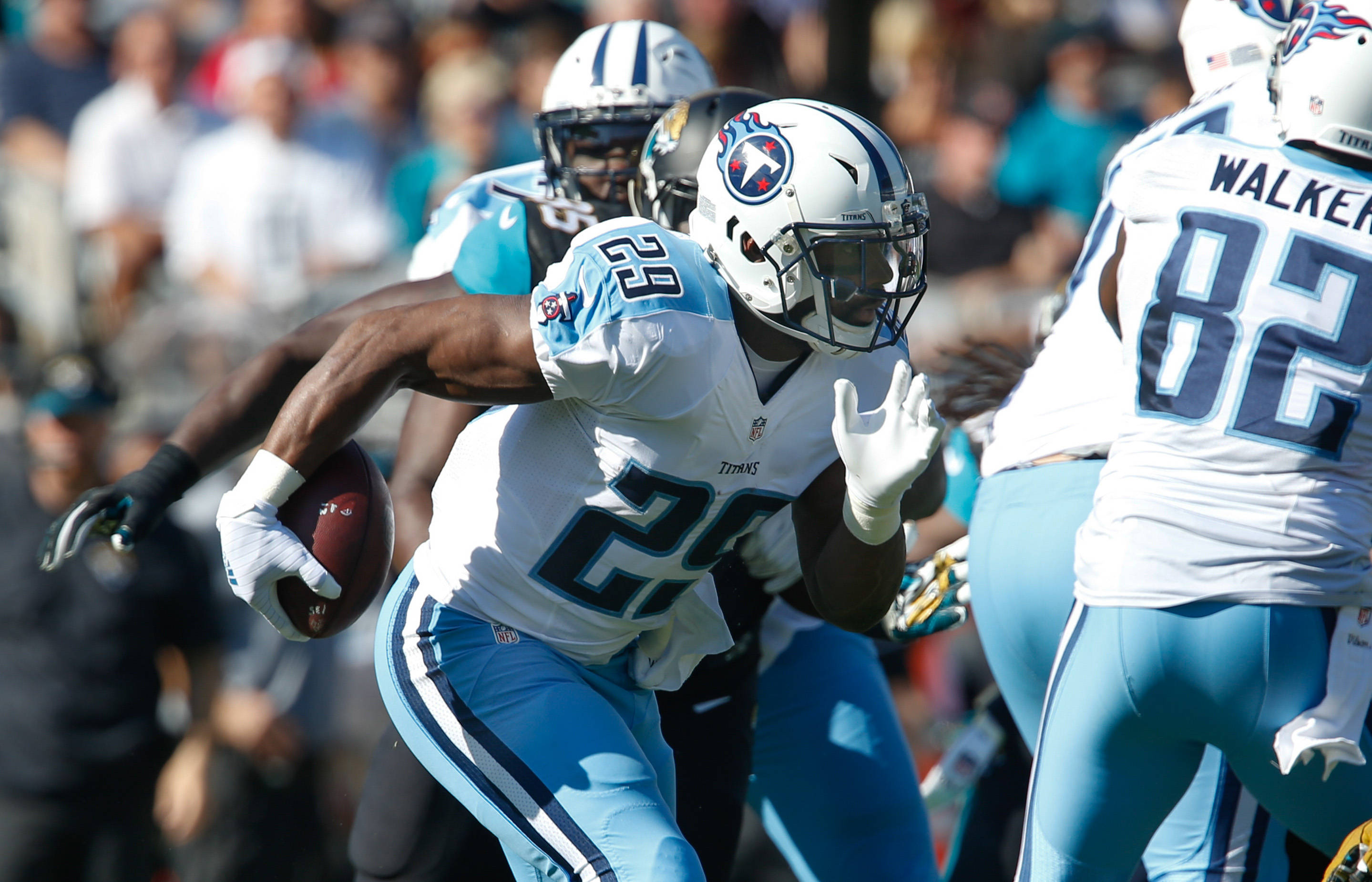 田納西泰坦隊 DeMarco Murray 壁紙 — 一名身穿白色和淺藍色球衣的田納西泰坦美式足球員在日間比賽中持球衝刺。