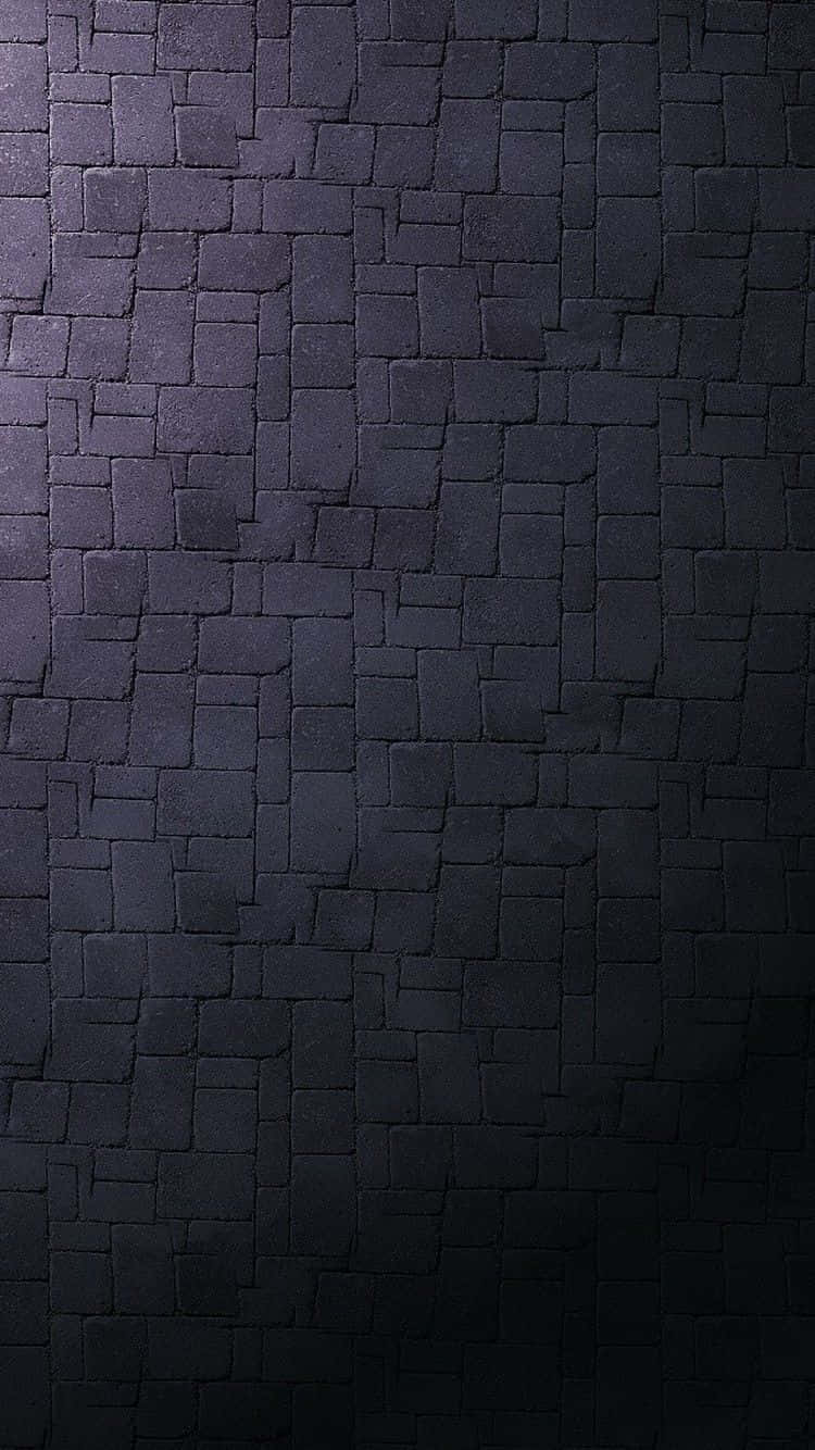 Dark Wall 桌布 壁紙 — 由不規則黑色石磚製成的深色紋理牆壁特寫，帶有微妙的燈光漸變。