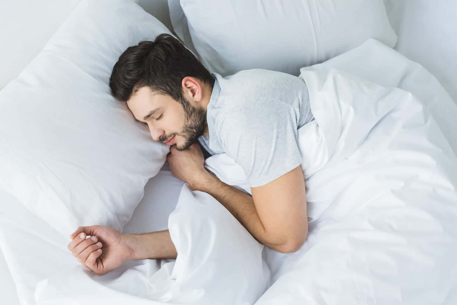男人在床上蓋著白色床單睡覺 壁紙