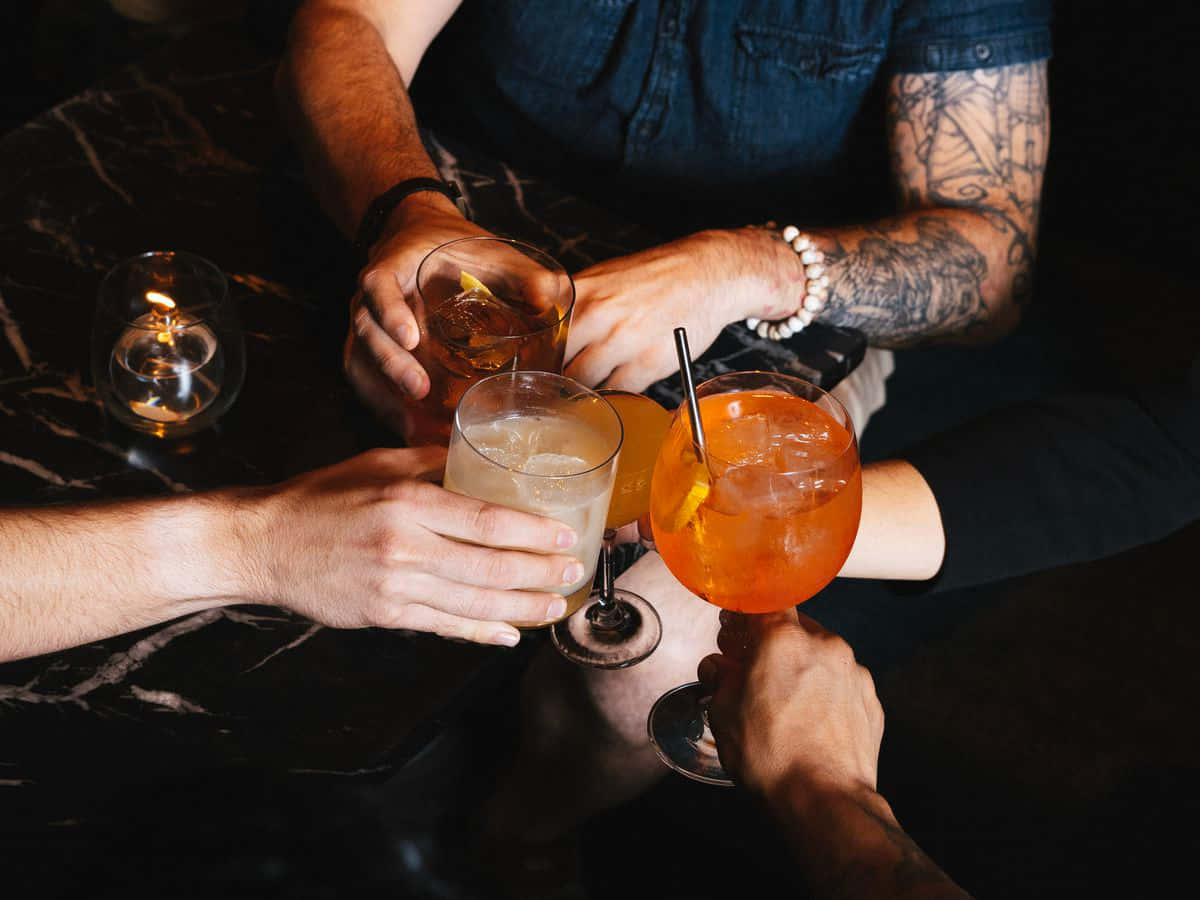 朋友們在燭光昏暗的酒吧裡為雞尾酒乾杯。