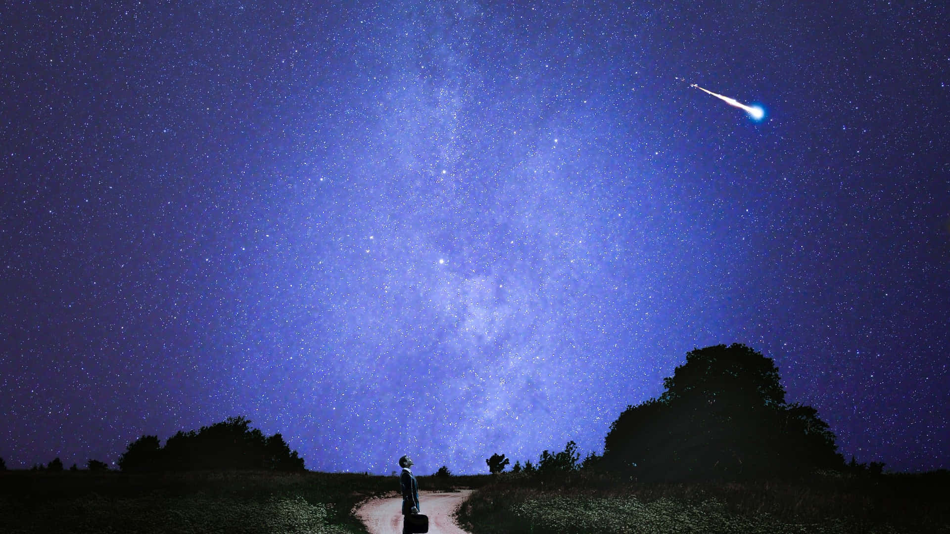 一個人站在星空下的路上，有流星