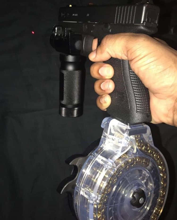 手握改裝手槍，附手電筒和鼓形彈匣