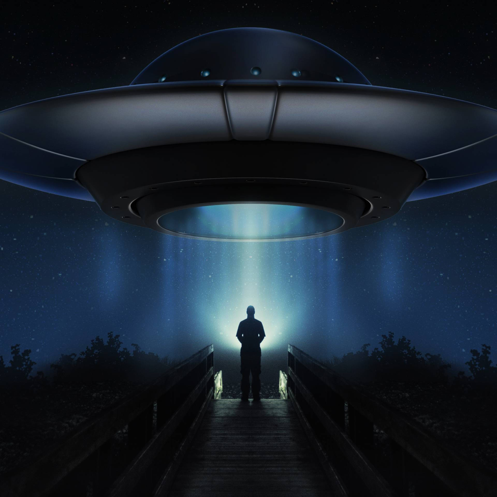 橋上的人影仰望星空夜空中發光的UFO的剪影。