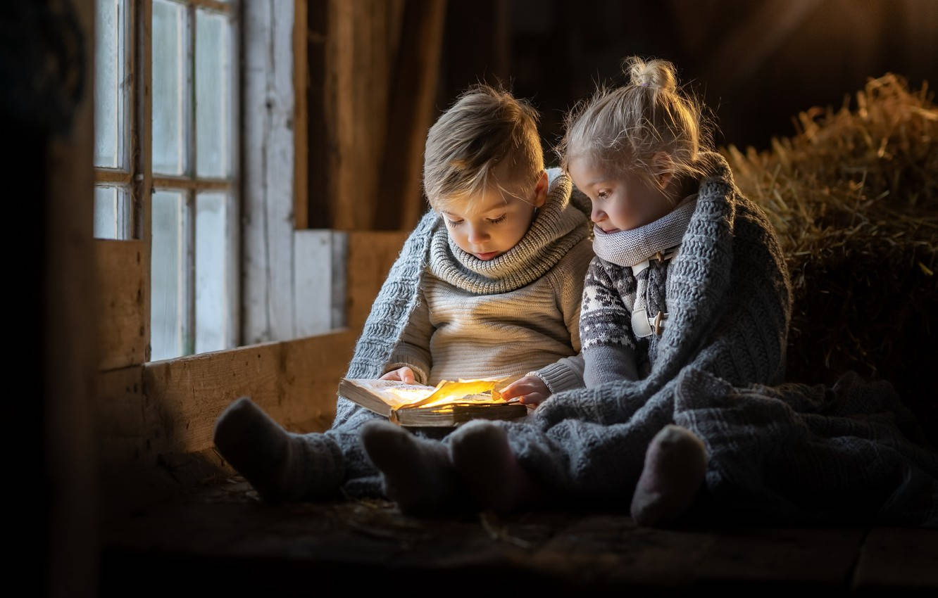 兩個孩子在穀倉窗邊的溫暖毯子下一起讀書。