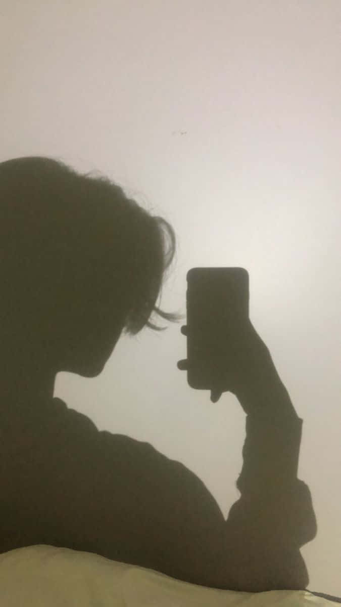 喺昏暗房間用電話自拍嘅人。