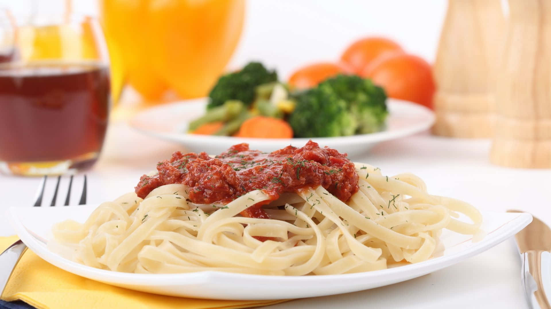 番茄醬淋 linguine 義大利麵 1920x1080 背景 壁紙 — 一盤配有濃郁番茄醬和新鮮香草的意大利寬麵條，旁邊有蒸蔬菜和飲料，準備好享用。
