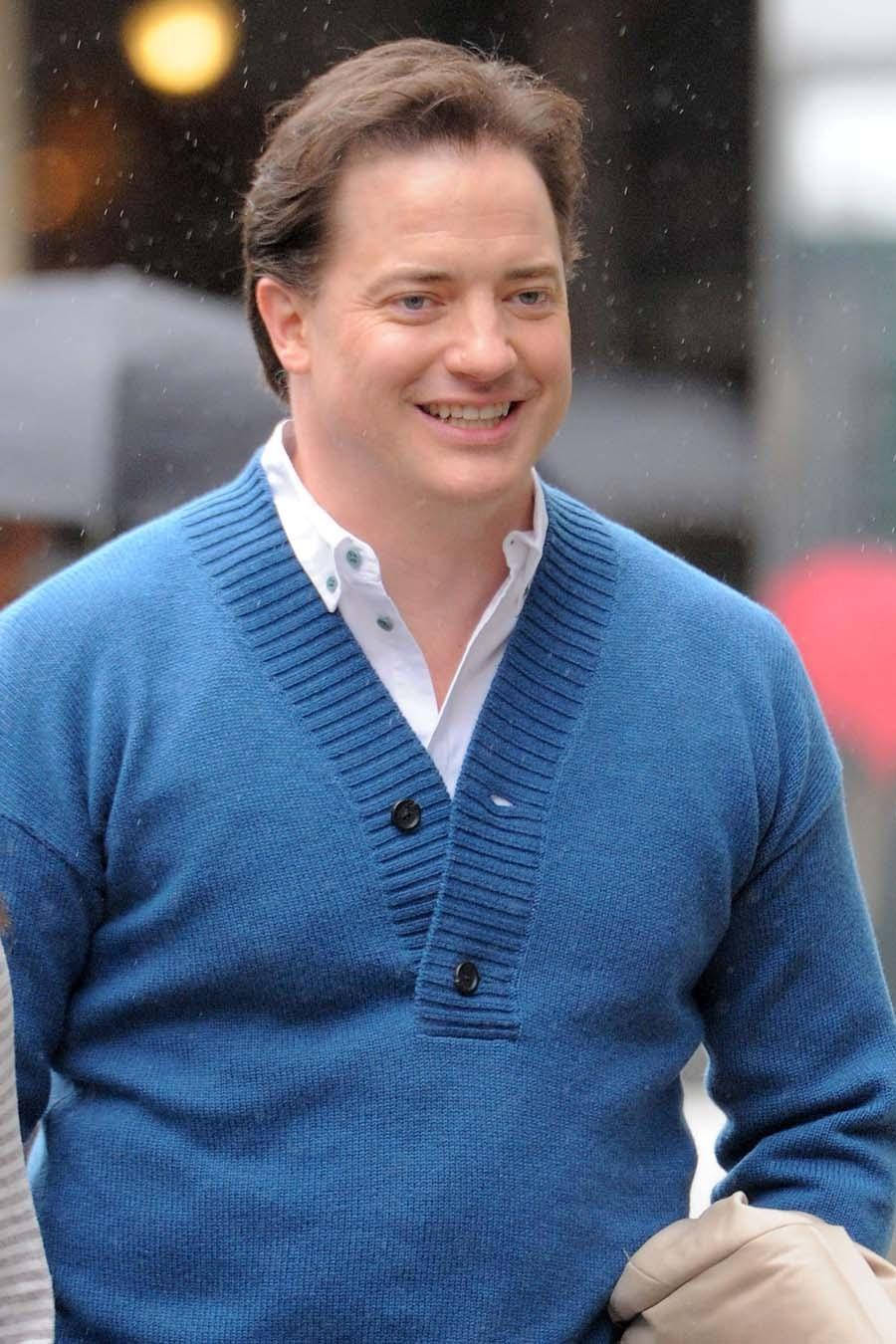 穿藍色開襟衫的男子在雨中微笑