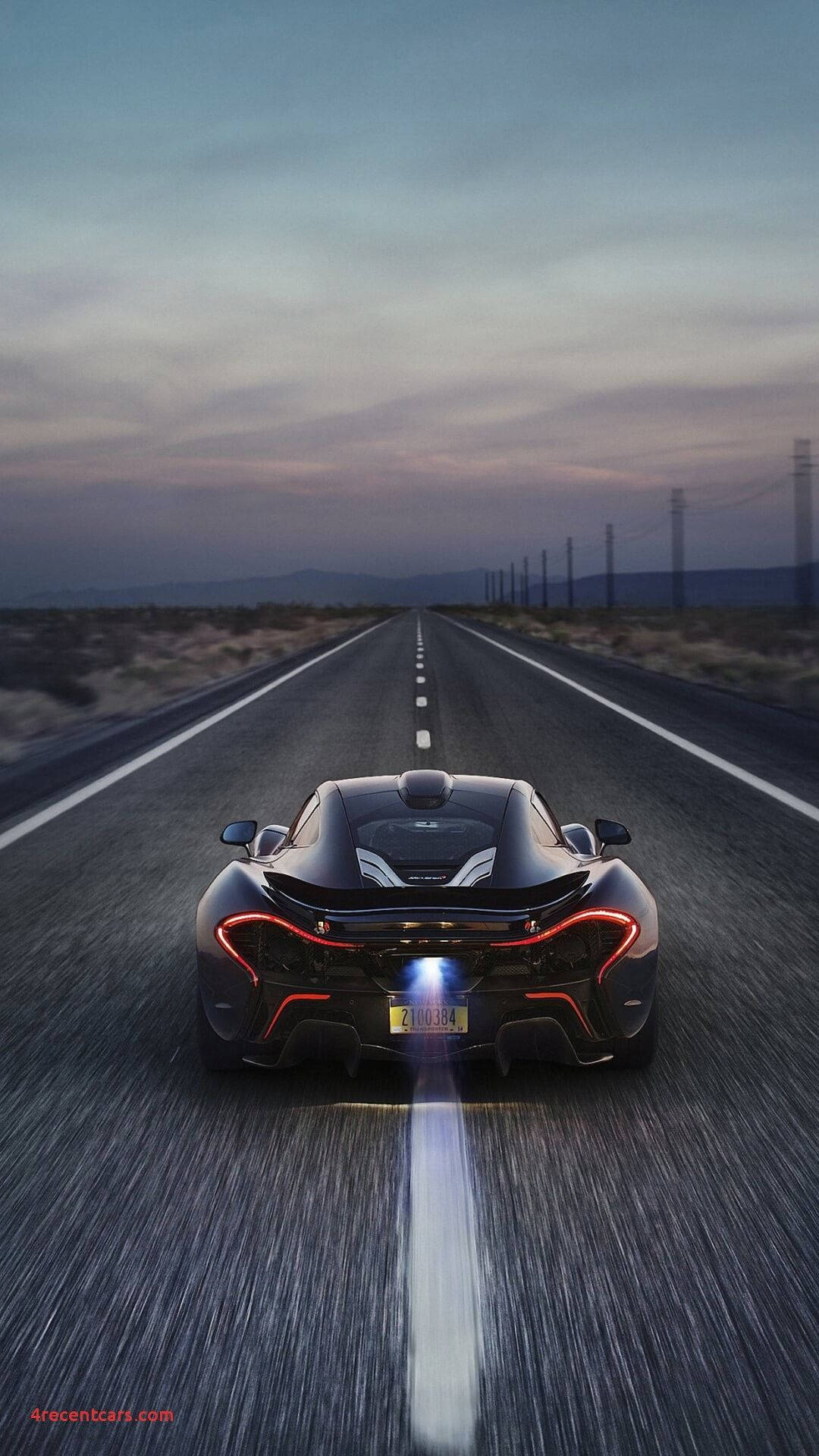 黑色McLaren在黃昏時分沿沙漠高速公路飛馳，尾燈發紅光。