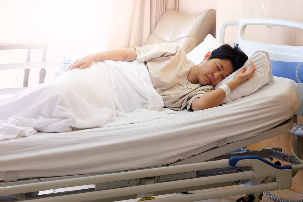 年輕男子在醫院床上休息，帶有靜脈輸液管