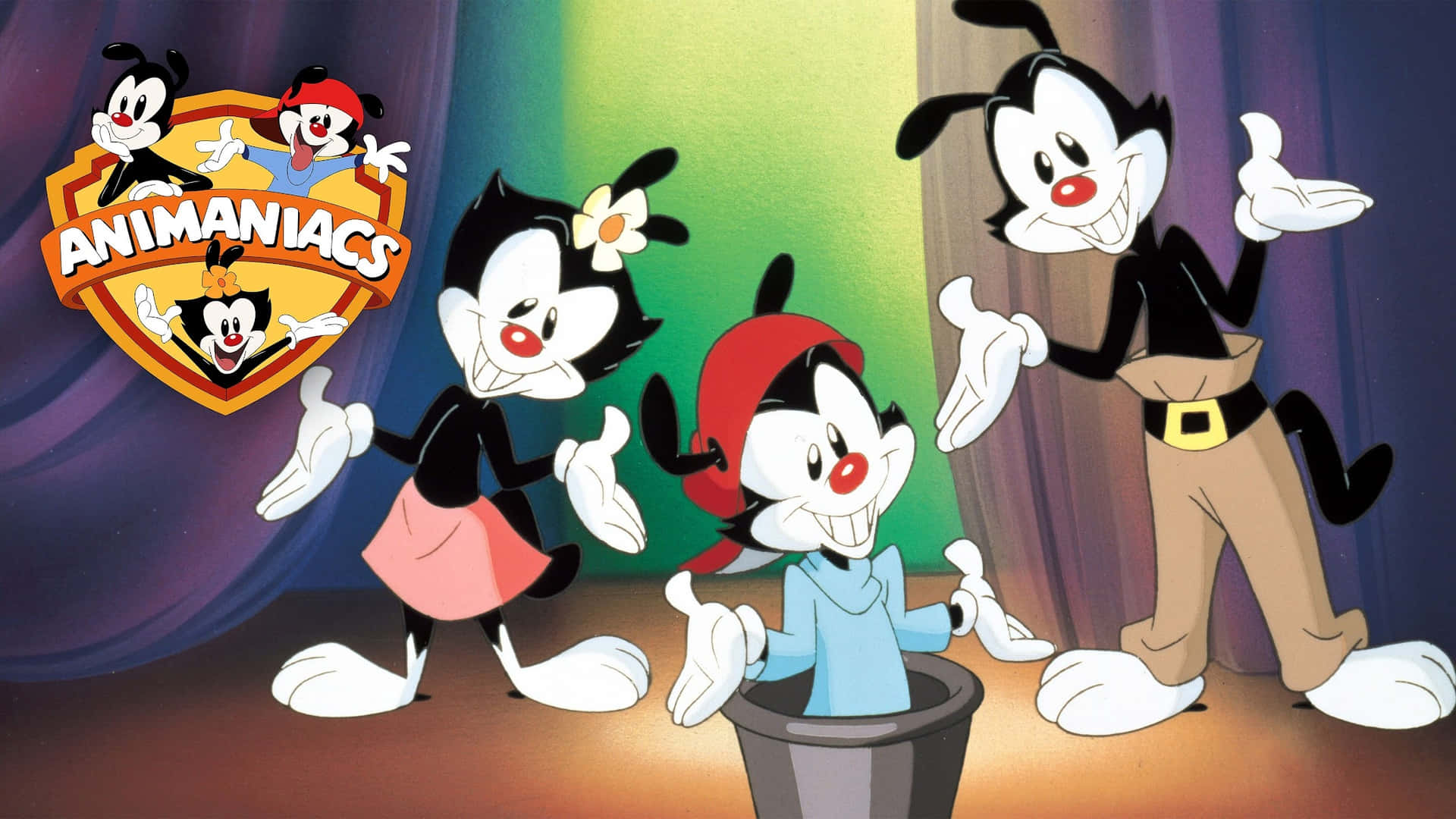 來自《Animaniacs》的三個卡通角色站在有彩色窗簾的舞台上。