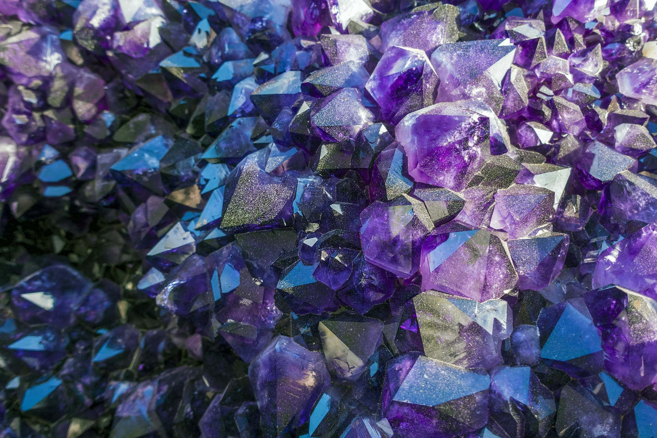 療癒靈魂的水晶 壁紙 — 閃爍紫色紫水晶晶體的近距離特寫，銳利的刻面捕捉豐富色調的光線。