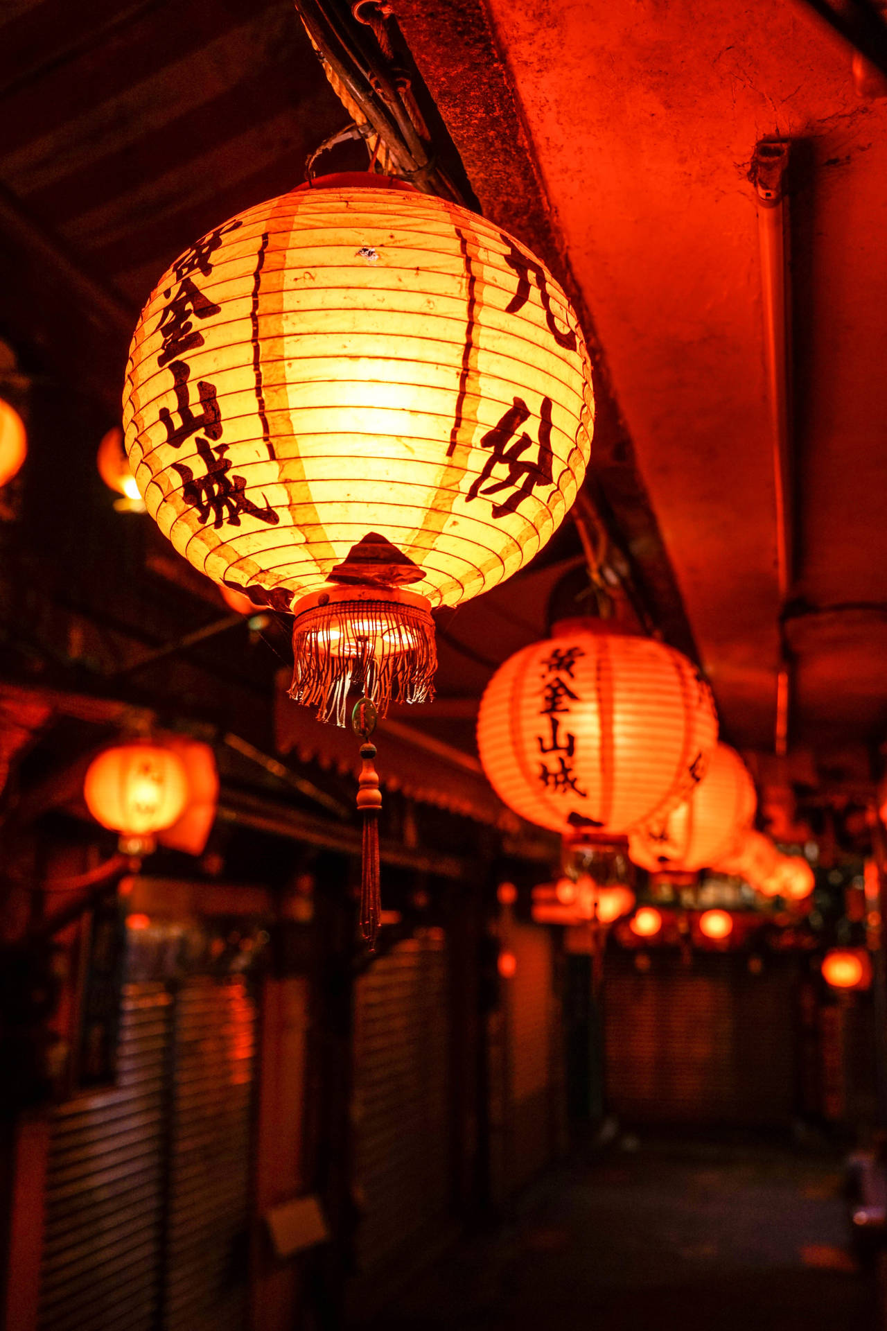 一排發光的日本燈籠照亮夜晚的狹窄小巷。