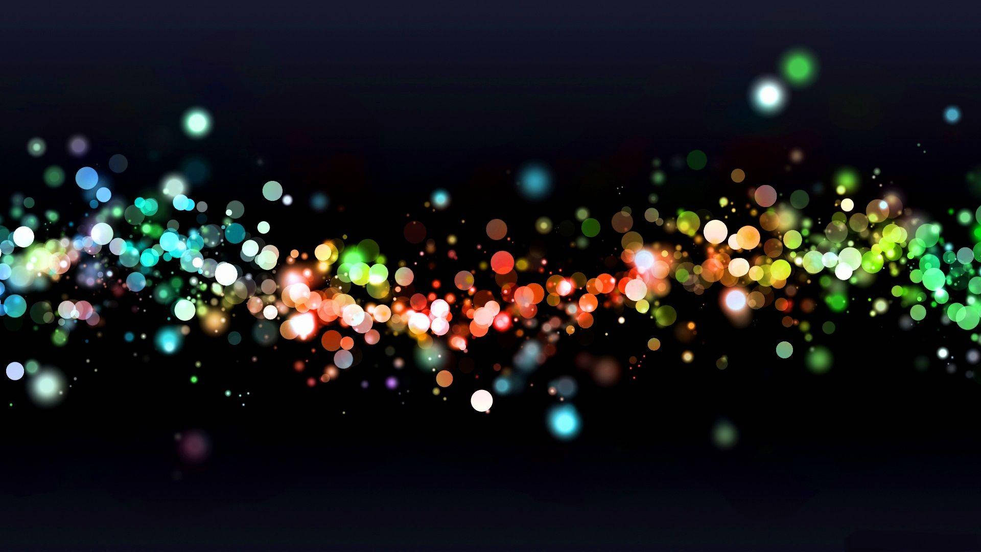 發光散景光點高清圖 壁紙 — 色彩繽紛的散景燈光形成一道充滿活力的波浪，在深色背景上流動，營造出動態的抽象光芒。