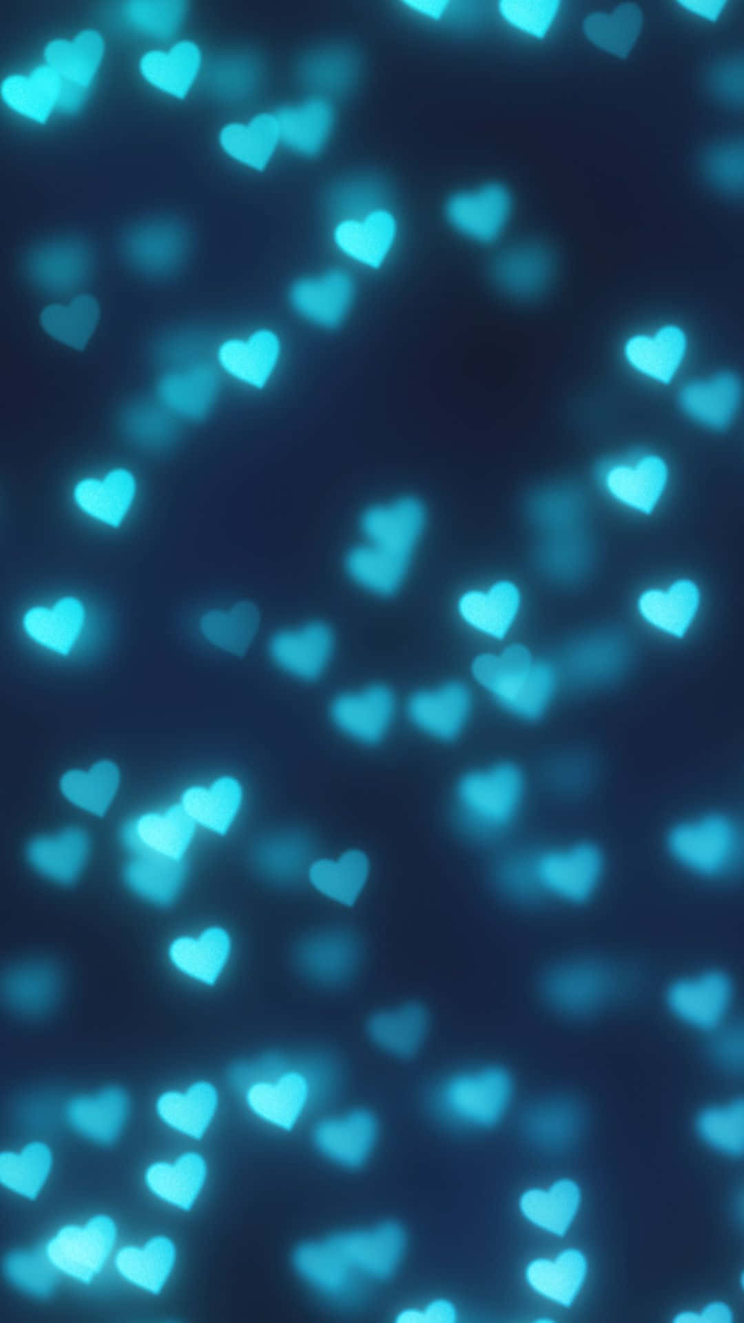 Blue Heart 桌布 壁紙 — 發光的綠松色心形在深藍色背景上柔和漂浮，呈現夢幻般的散景效果。