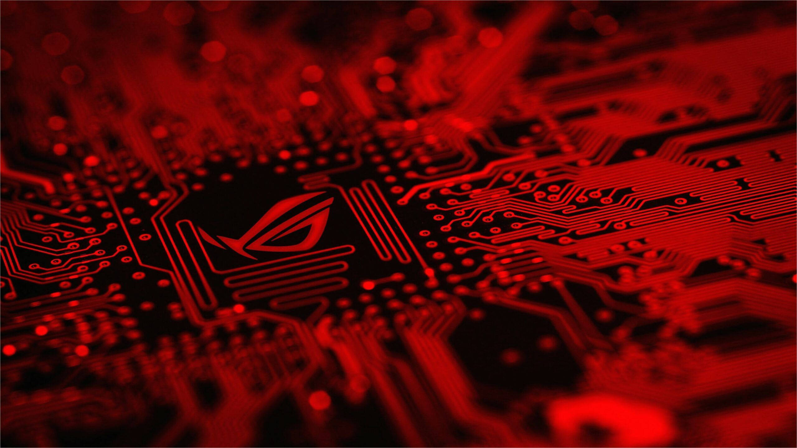 Black And Red Gaming 桌布 壁紙 — 發光紅色電路板特寫，中央有發光的ROG眼睛標誌。