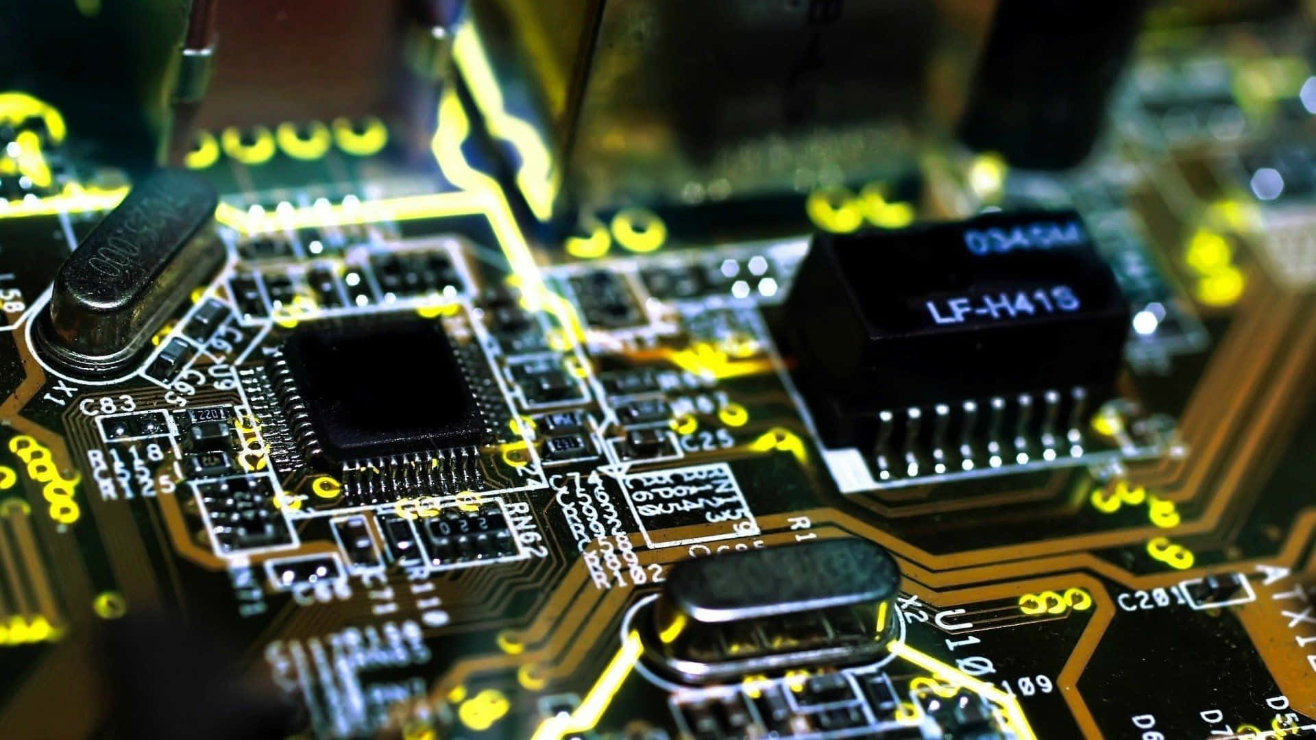 Electronics 桌布 壁紙 — 發光黃色電路板的特寫，具有複雜的路徑和標籤的電子元件。