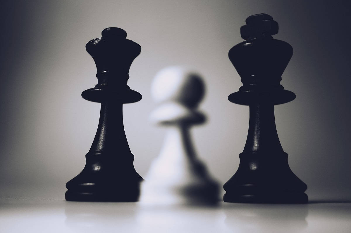 白兵棋風情 壁紙 — 兩個黑色國王棋夾著一個模糊的白色兵卒，構成鮮明的單色構圖。