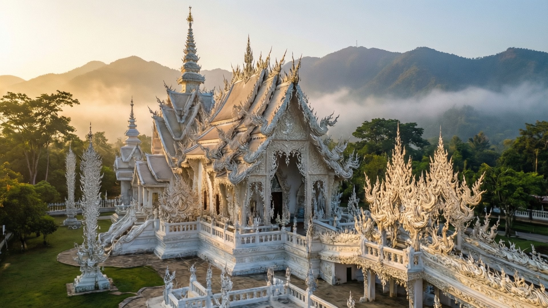 白色寺廟，尖頂，被霧氣繚繞的山脈環繞，日出時分。