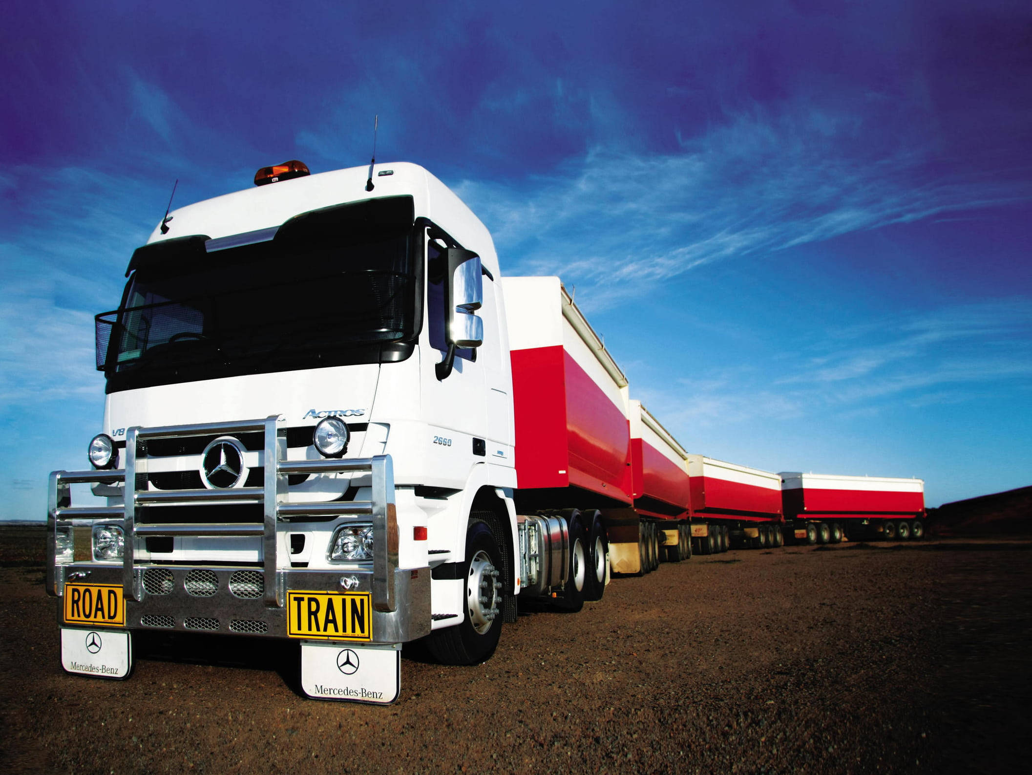 白紅配色冷氣卡車 壁紙 — 一架白色Mercedes-Benz Actros貨車連紅色拖車停泊在泥路上，天空蔚藍，白雲輕飄。