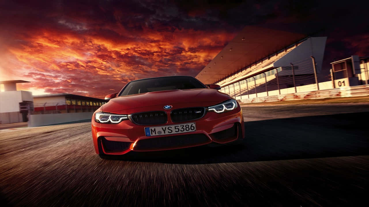 「白色720p寶馬敞開引擎蓋」 壁紙 — 一輛紅色BMW M4在火紅橙紫相間的夕陽天空下於賽道上飛馳。