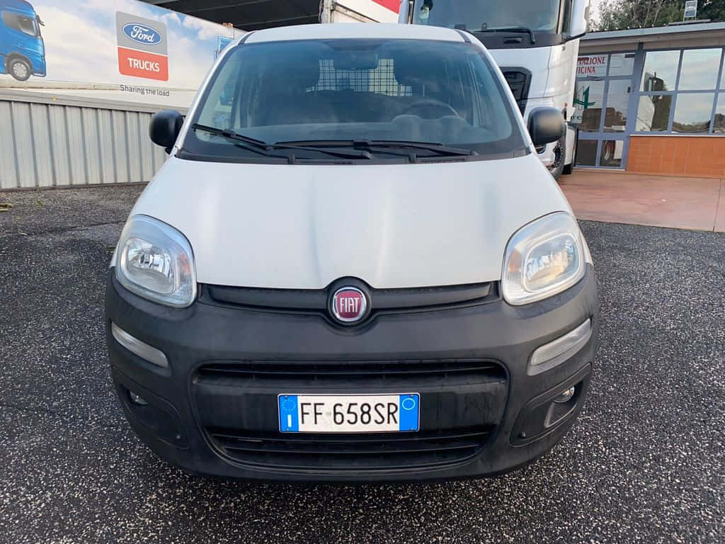 Fiat Panda 桌布 壁紙 — 白色Fiat Panda正面視圖，停泊在福特卡車經銷商大樓附近的瀝青路上。